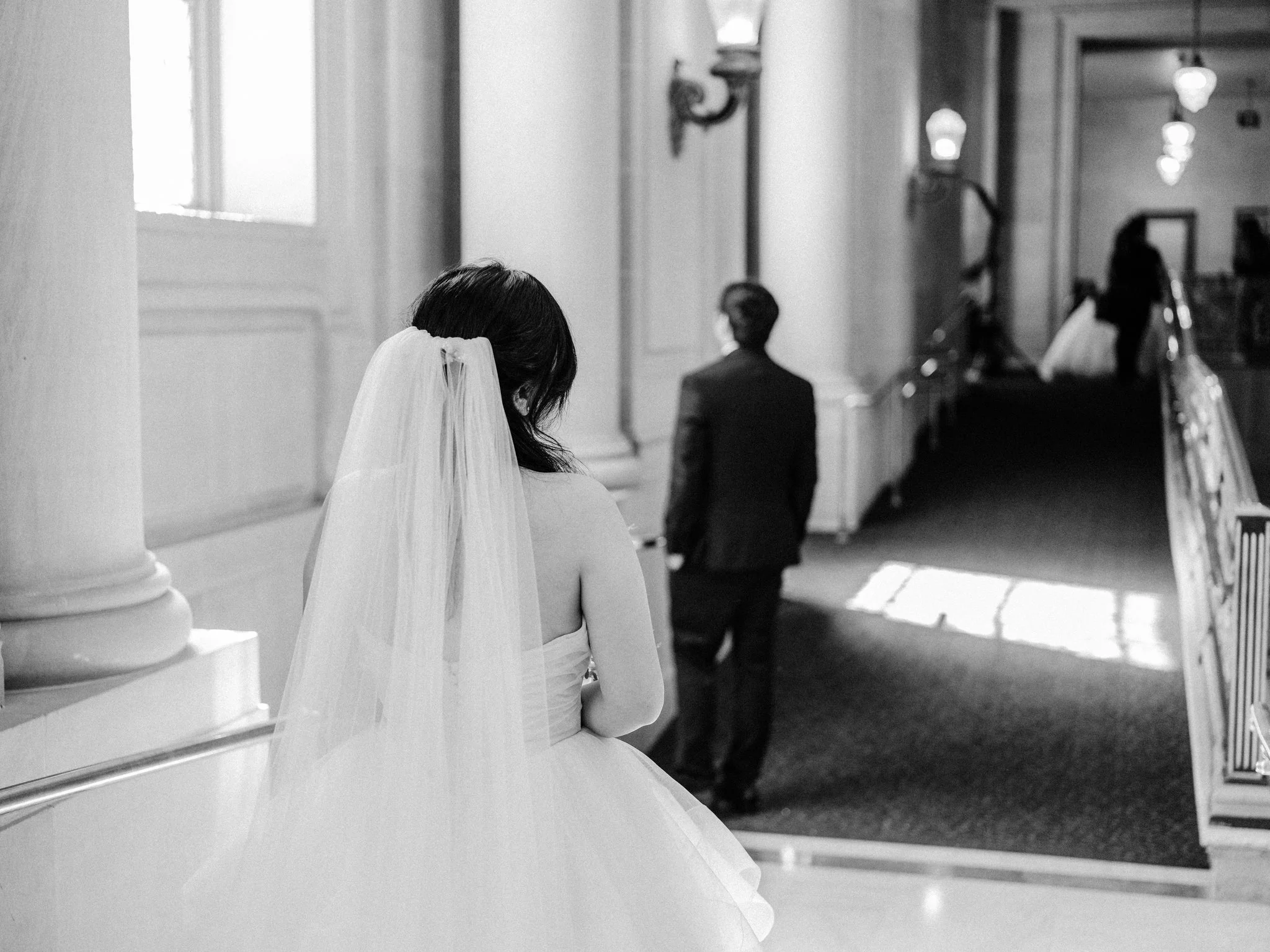 Bride standing behind groom before first look at San Francisco City Hall wedding