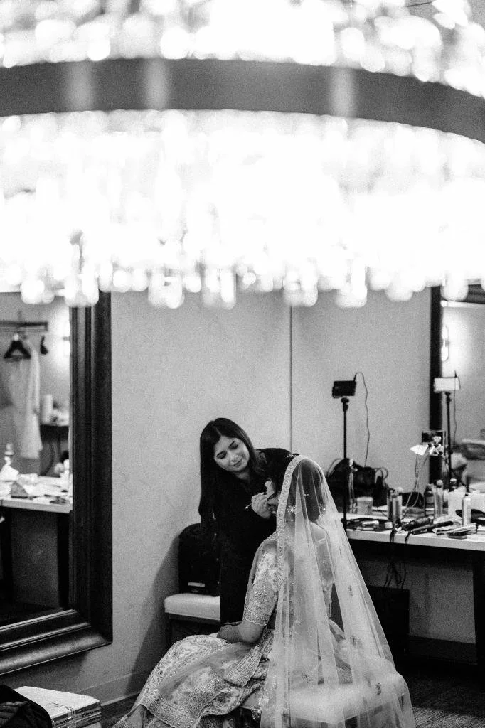 Bride having her makeup done while getting ready for the wedding