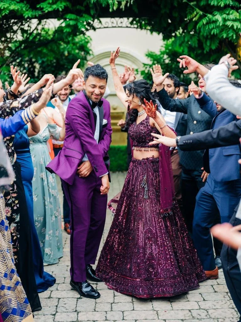 Bride and groom making their entrance onto the dance floor as guests celebrate