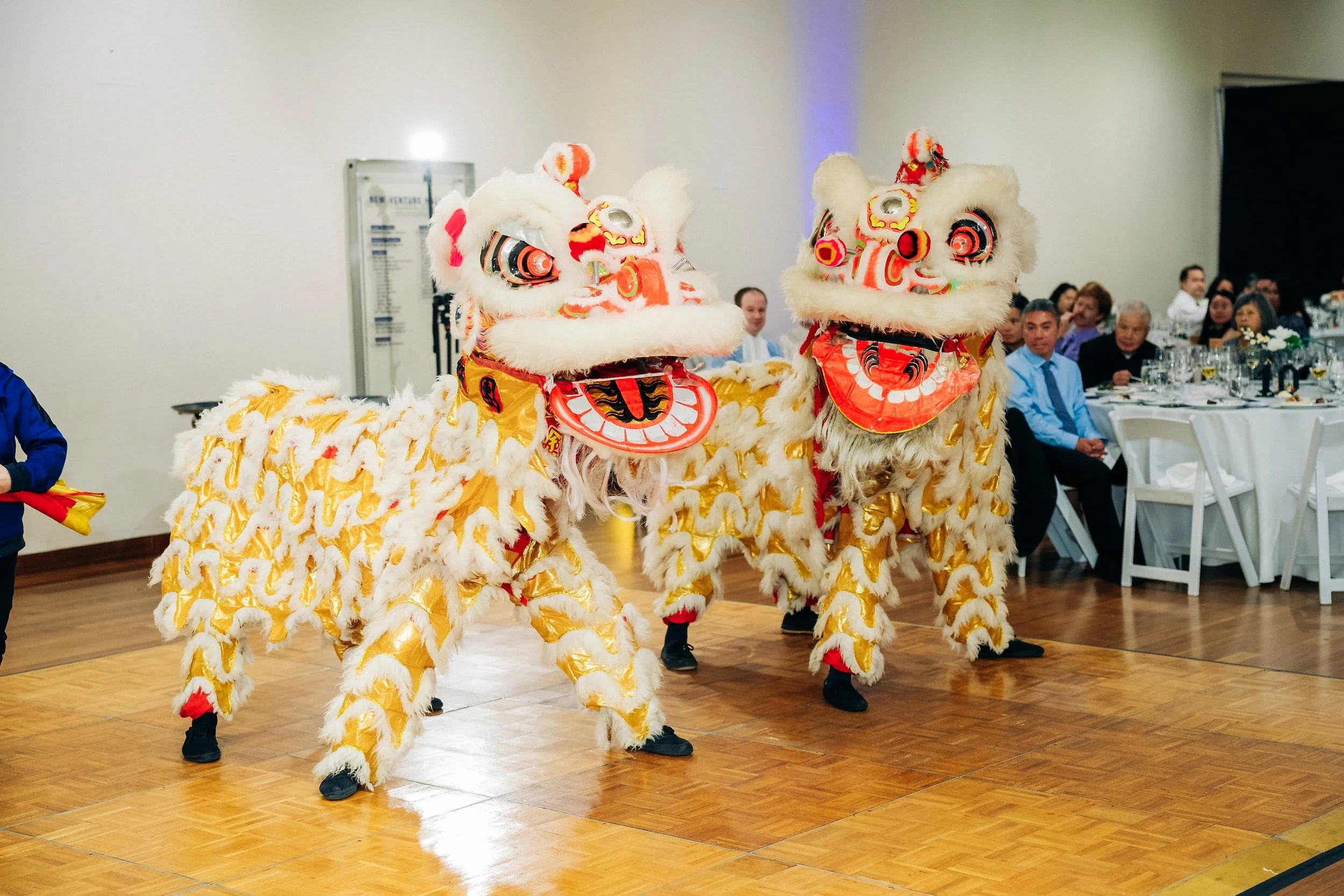 Chinese lion dance performance during wedding reception featuring traditional red and gold lions