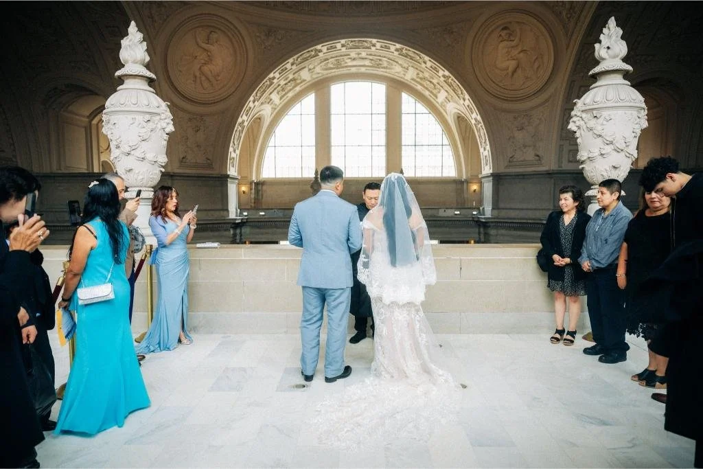 Bride and groom standing side by side facing the officiant.