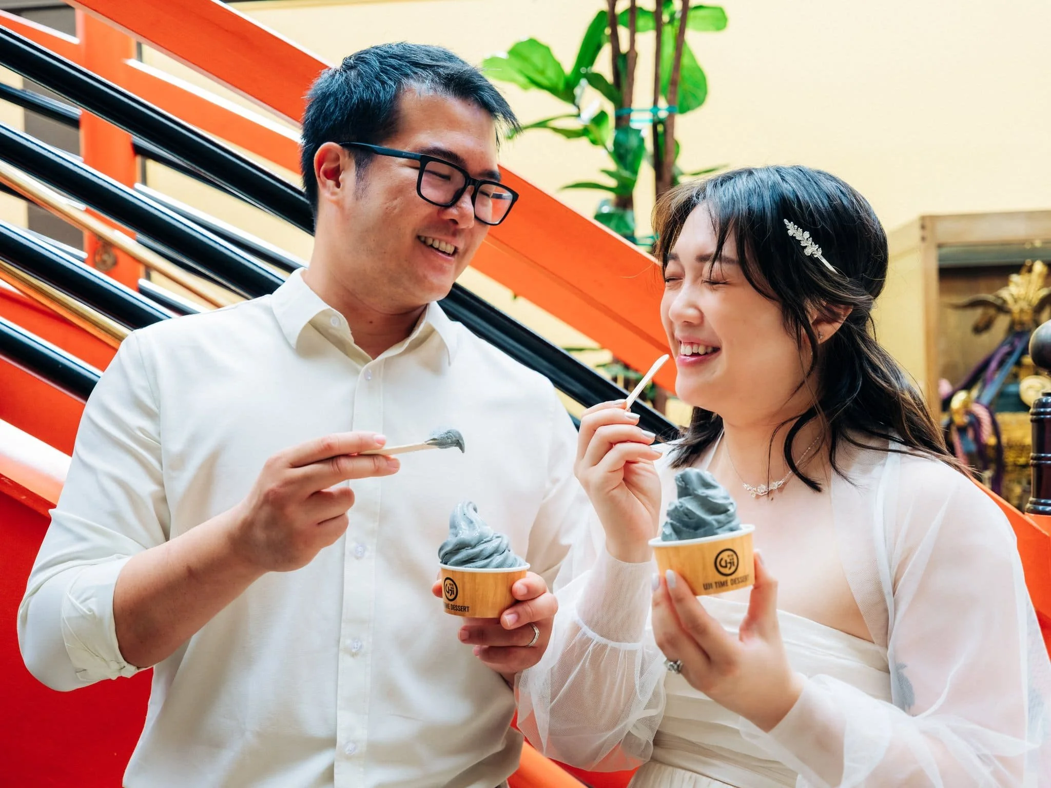 Bride and groom walking through San Francisco Japantown while eating soft serve ice cream during their elopement day.