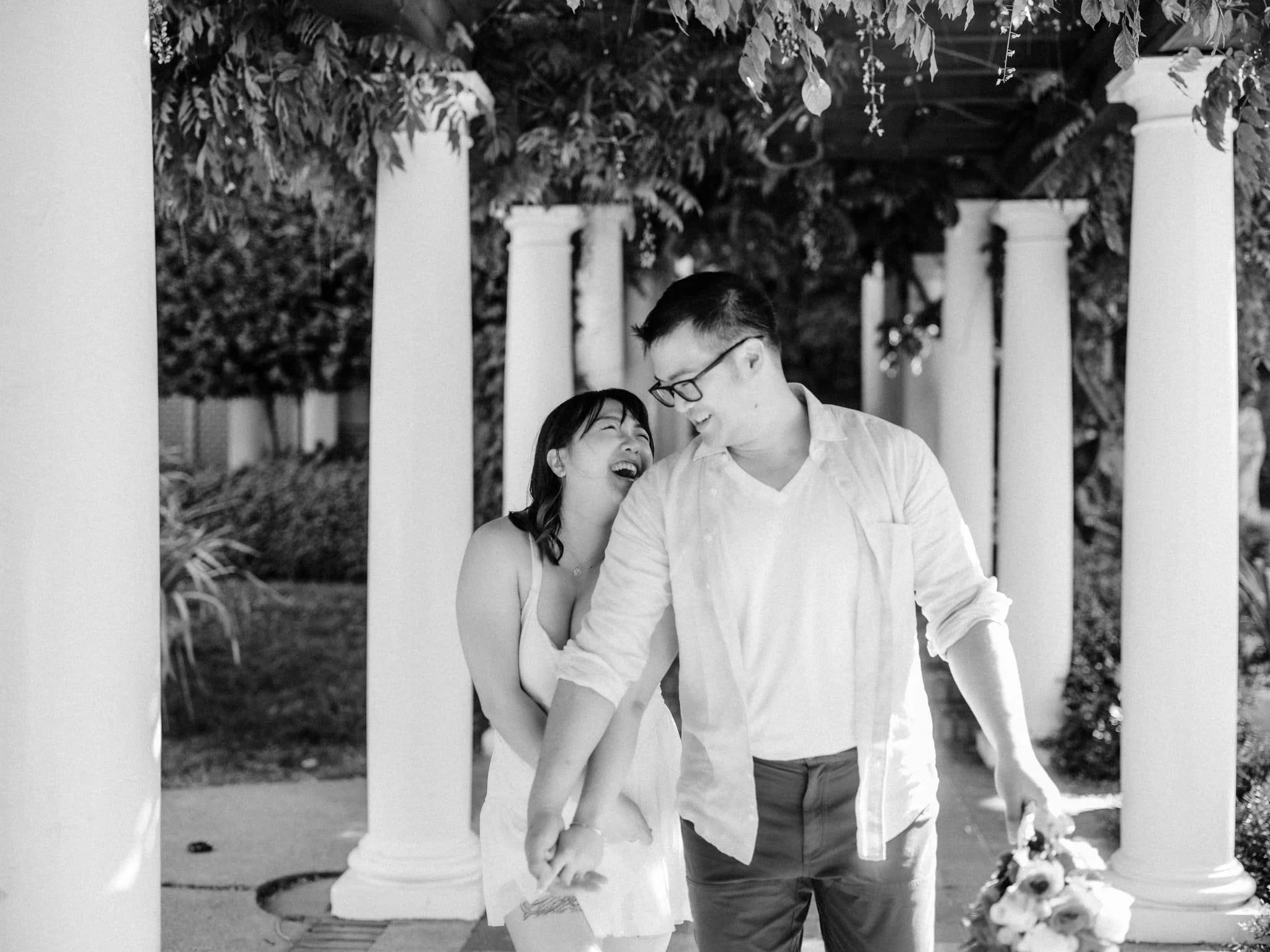 Couple holding hands and laughing during their engagement photos at Montalvo Arts Center in Saratoga.