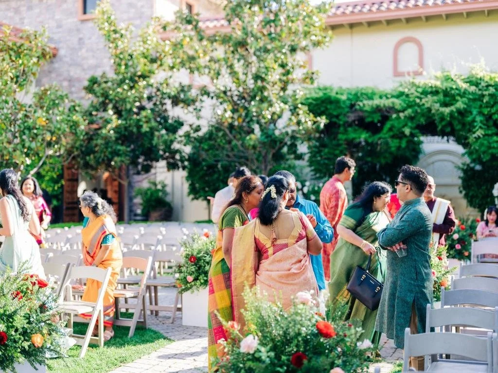 Wedding guests gathering around the ceremony seating before the celebration begins