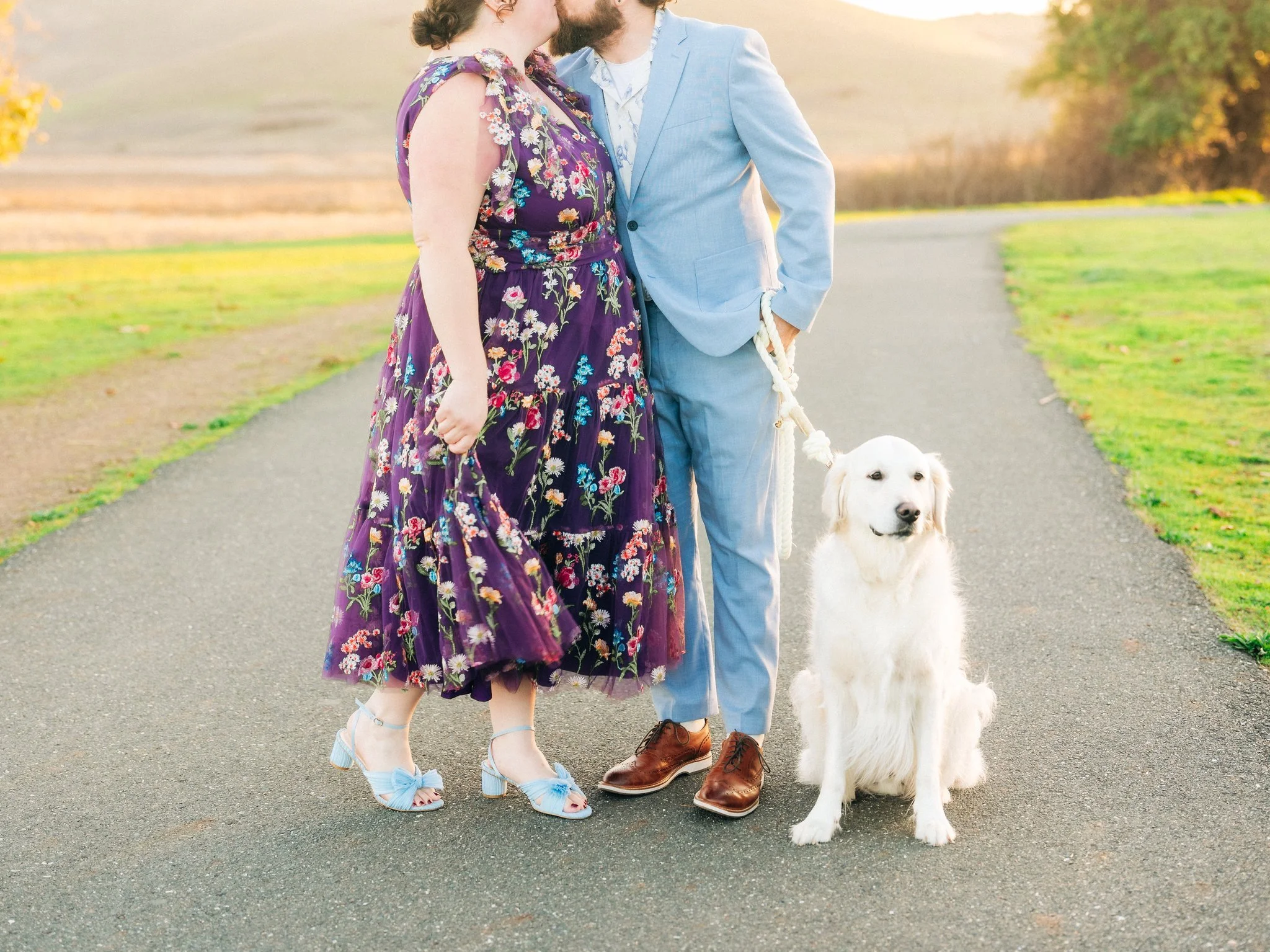 Couple dressed in formal attire kissing with their dog during a couples photo session at Coyote Hills Regional Park in Fremont CA