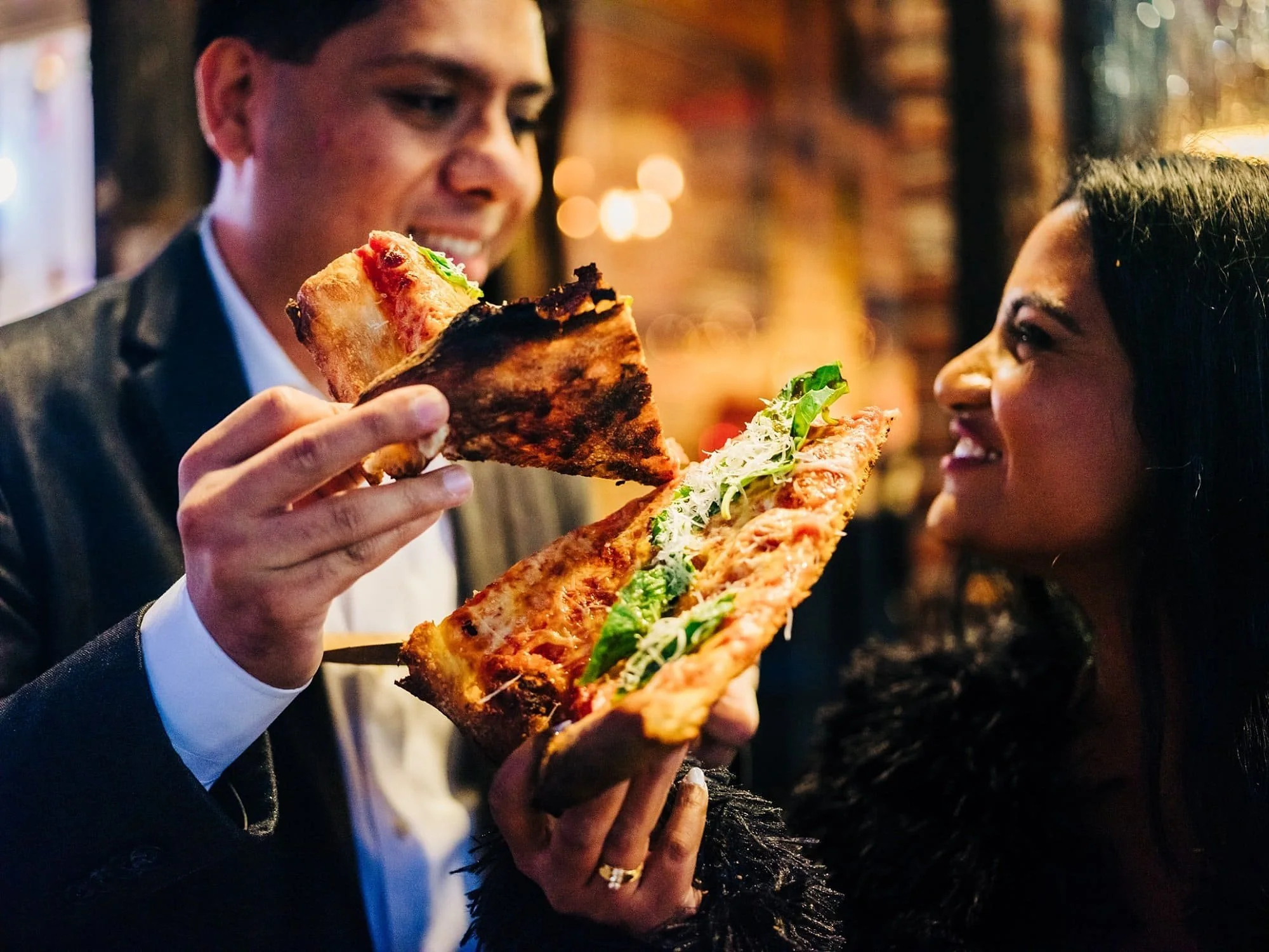 Close-up of couple sharing pizza during New York City engagement photos