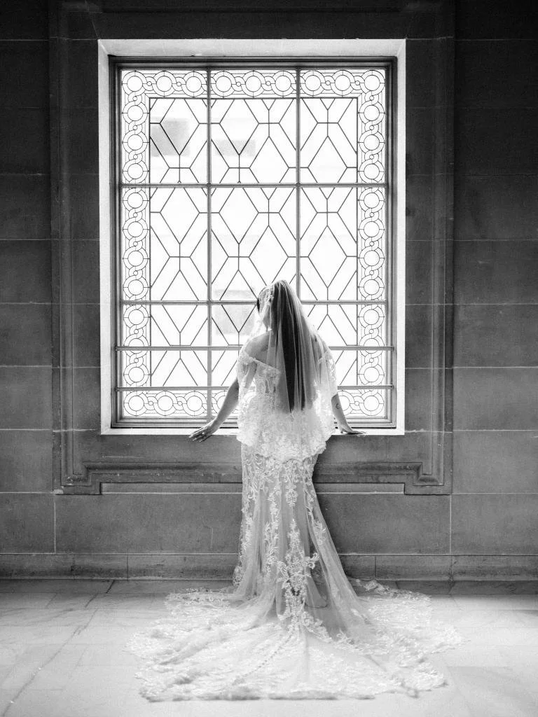 Bride looking out the stained glass window.