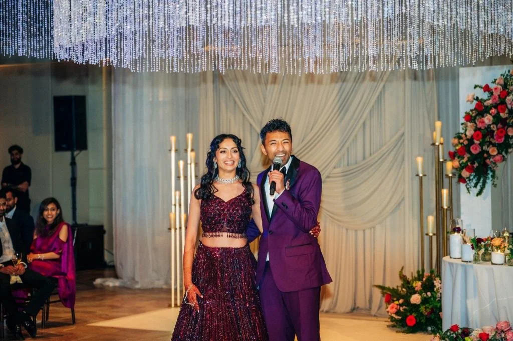 Groom giving a speech while standing beside the bride at their wedding reception
