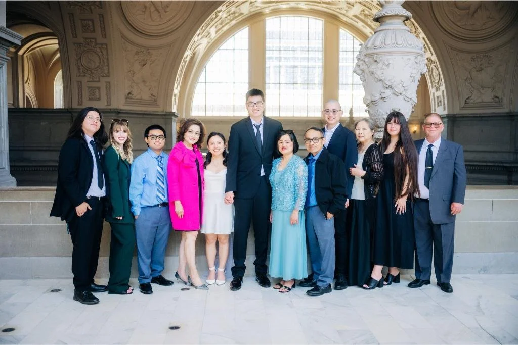 Bride and groom posing with their family after their San Francisco City Hall ceremony