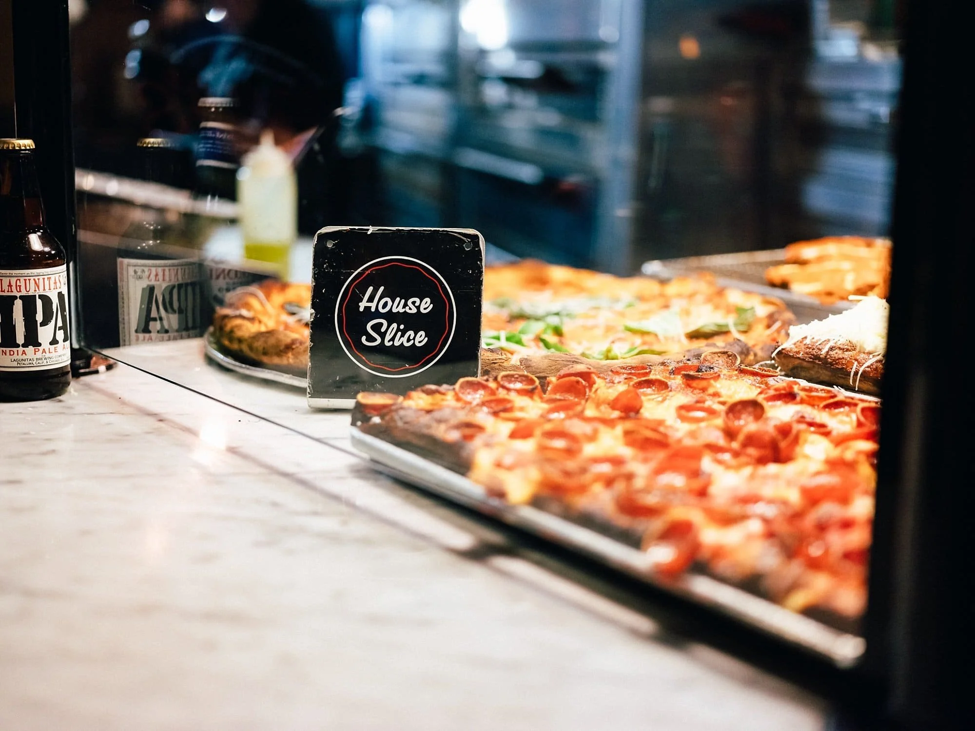 Close-up of classic New York pizza behind the counter during engagement session in NYC