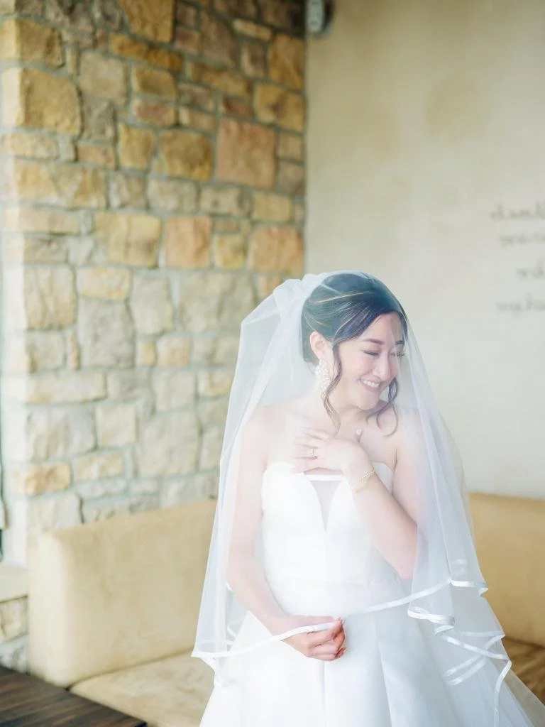 Bride posing for a portrait with her veil draped over her head