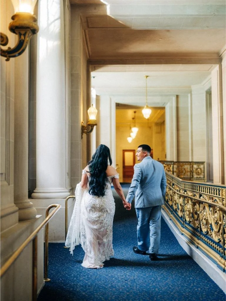 Bride and groom walking away from the camera hand in hand.