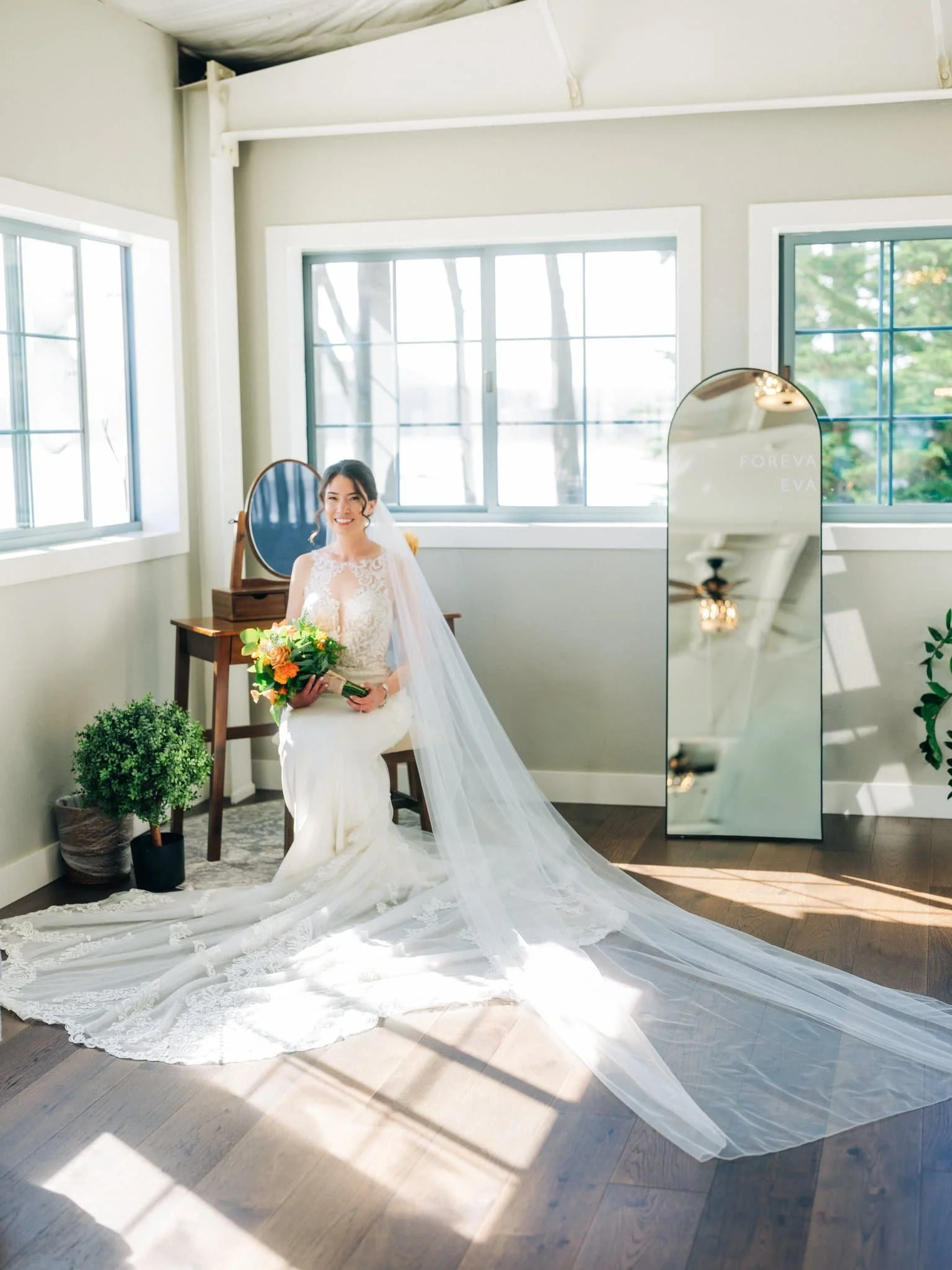 Bride posing with wedding bouquet in dressing room at Maverick’s Beach House wedding in Half Moon Bay