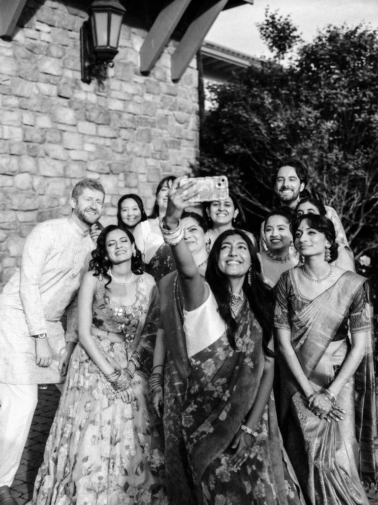Bride and bridal party taking a selfie together before the wedding celebration