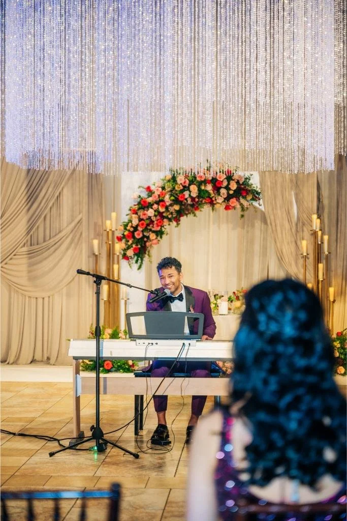 Groom singing while playing the piano during the wedding reception