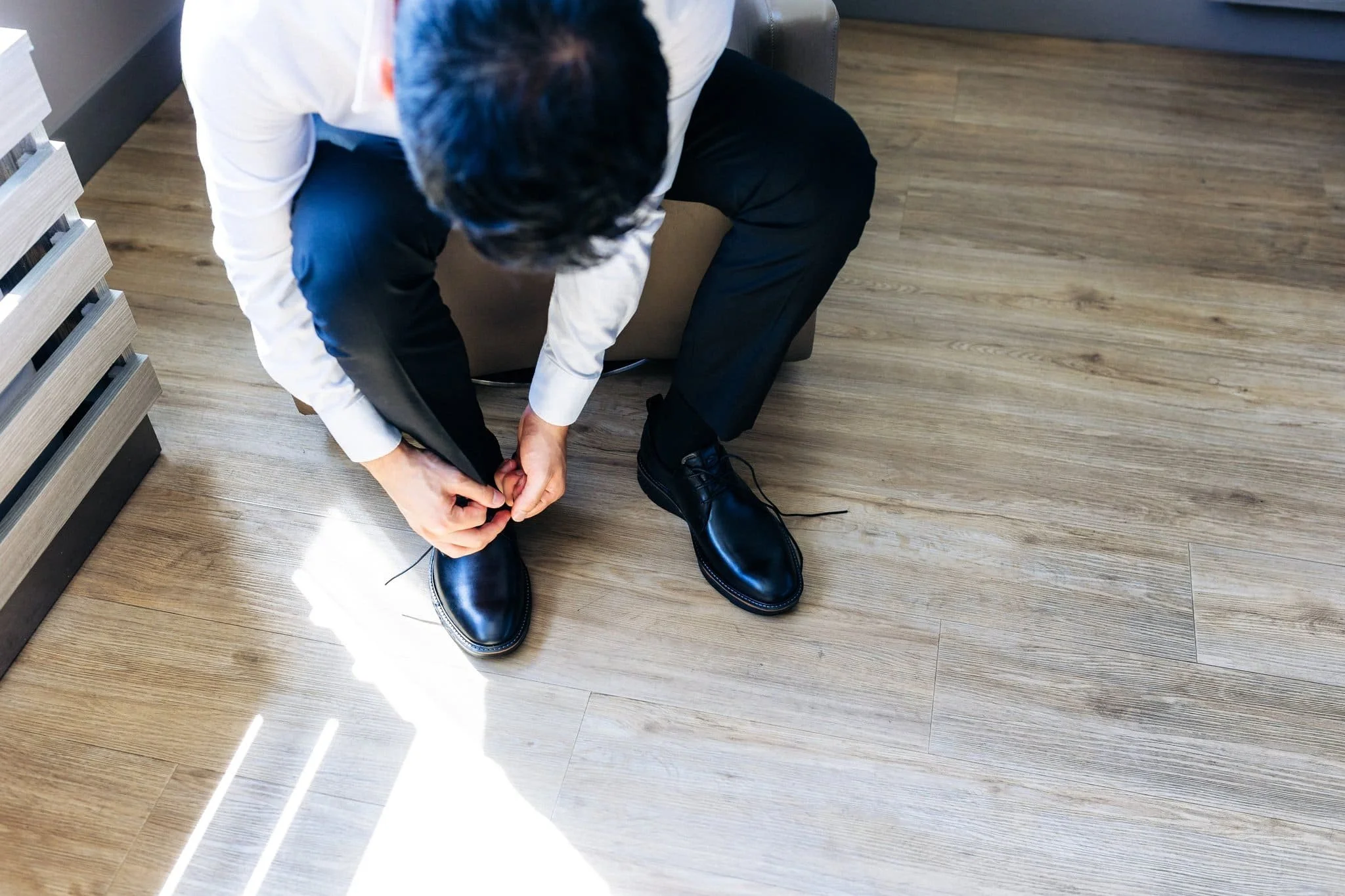 groom tying shoes getting ready dressing room palm event center pleasanton wedding