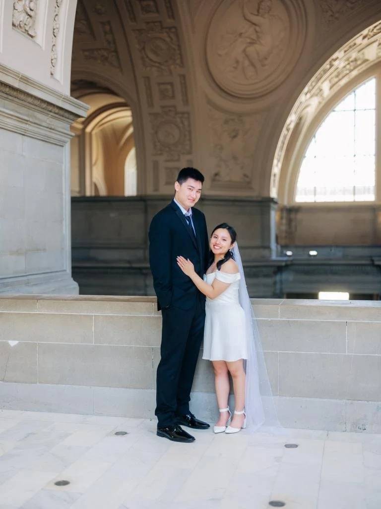 Newlyweds standing together after their ceremony with the bride's hand and wedding ring on the groom's chest