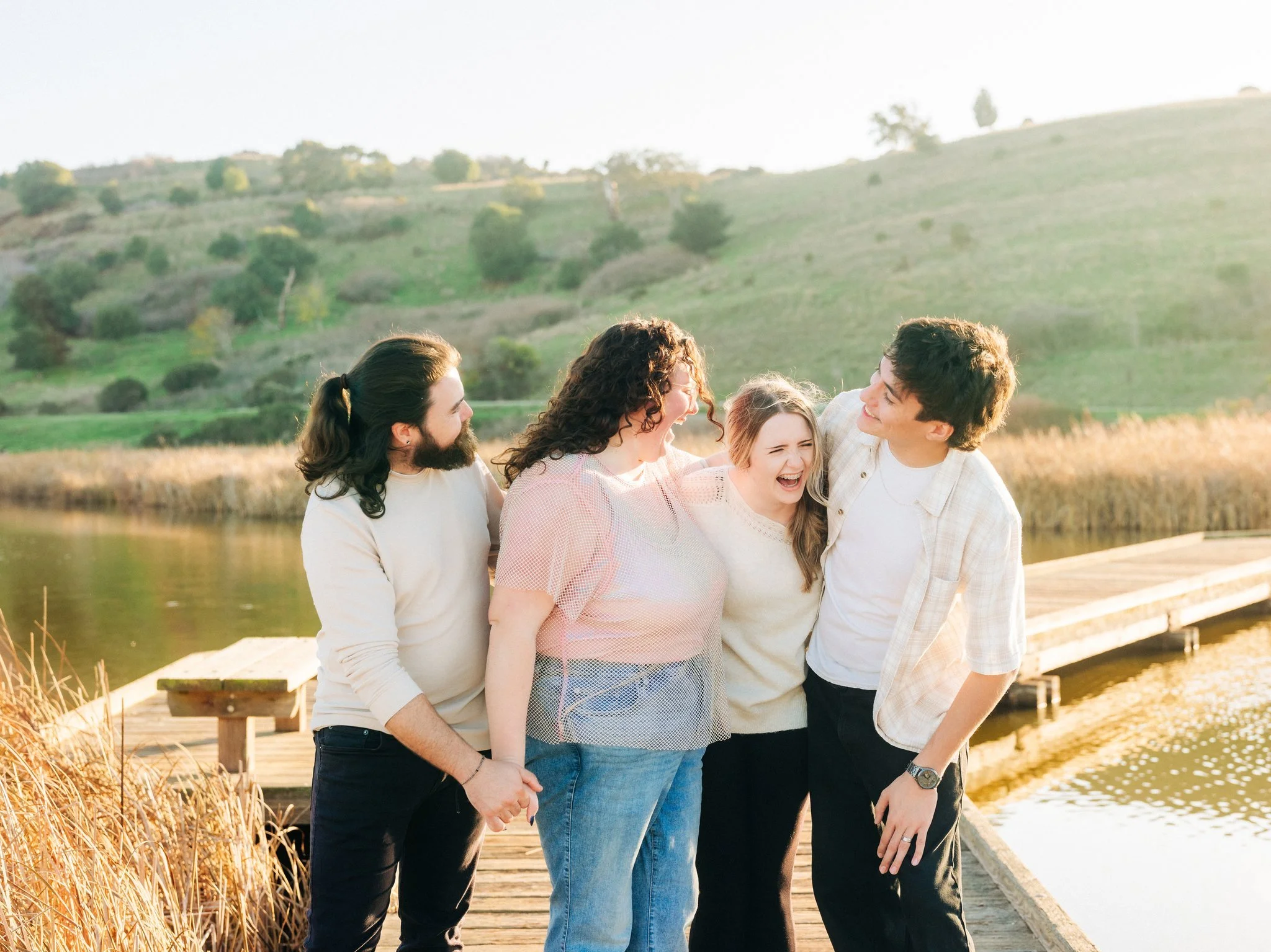 Couple smiling with their kids on a dock during a family and couples photo session at Coyote Hills Regional Park in Fremont CA