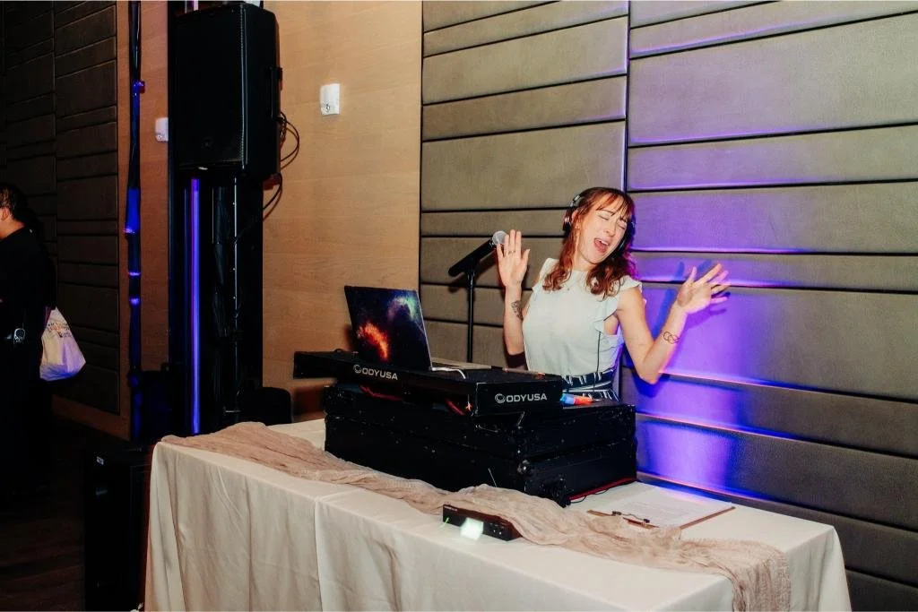 Wedding DJ smiling with his arms raised during the reception