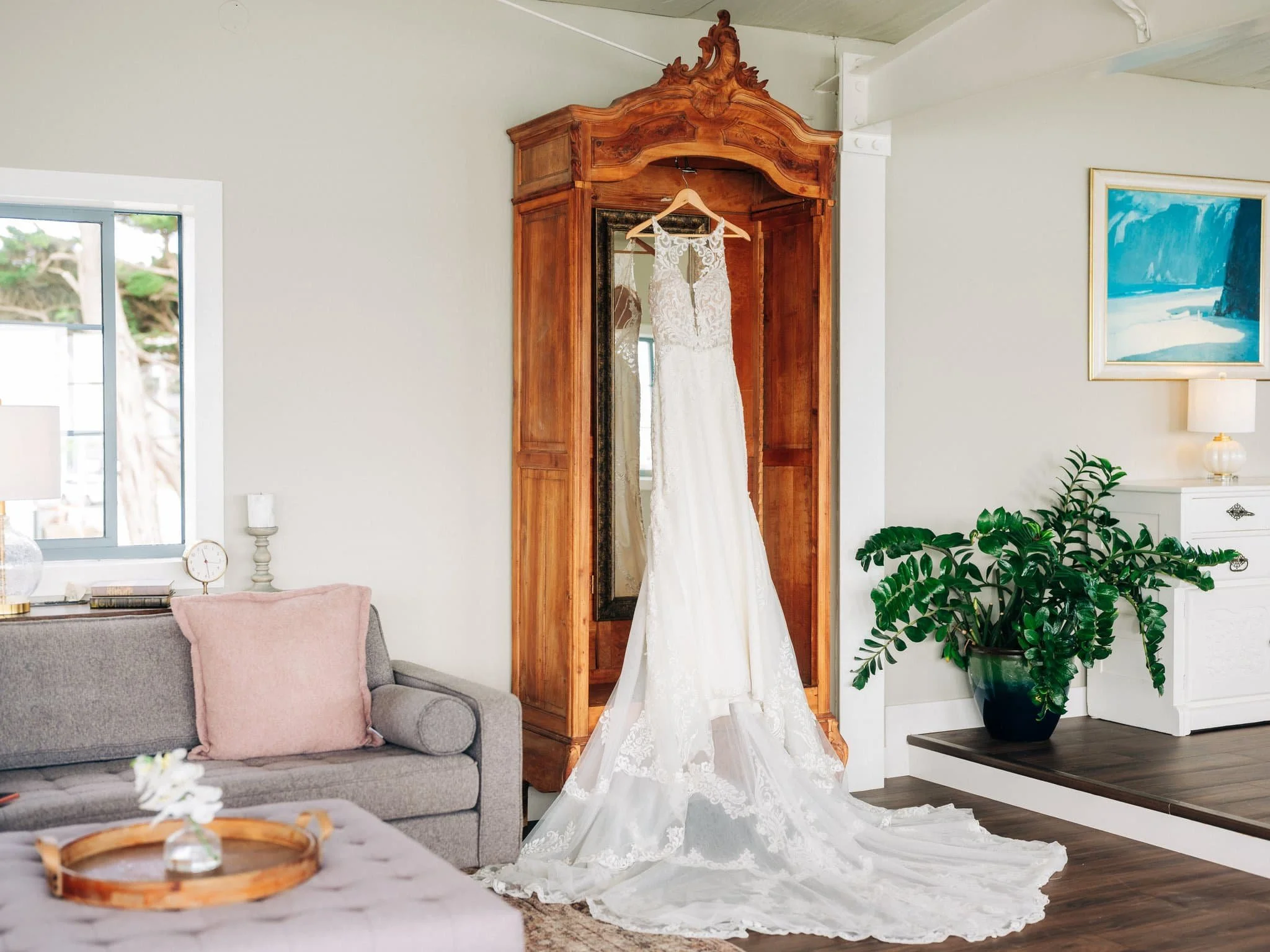 Wedding dress hanging in getting-ready suite at Maverick’s Beach House wedding in Half Moon Bay