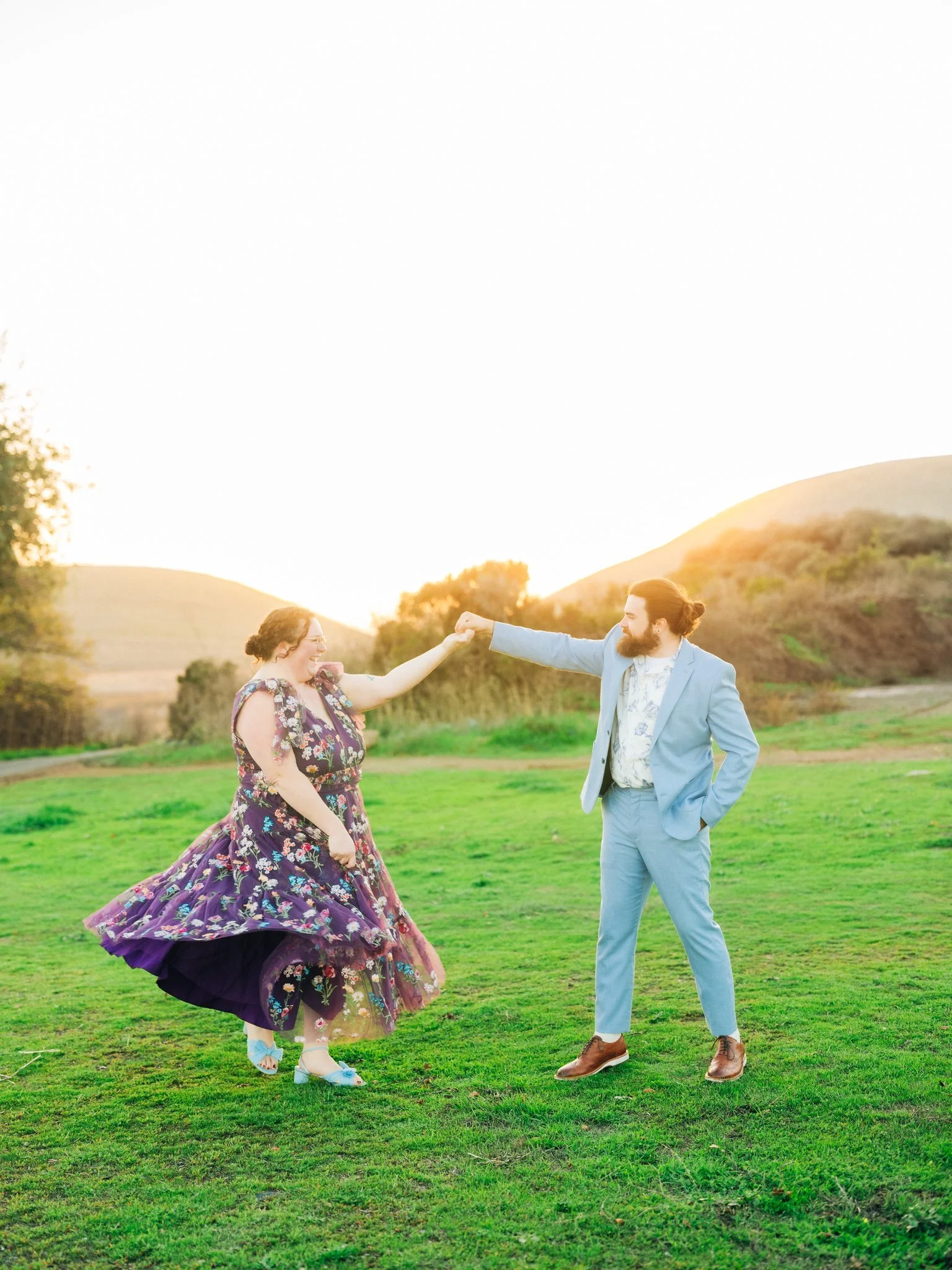 Couple dancing in the grass during a couples photo session at Coyote Hills Regional Park in Fremont CA