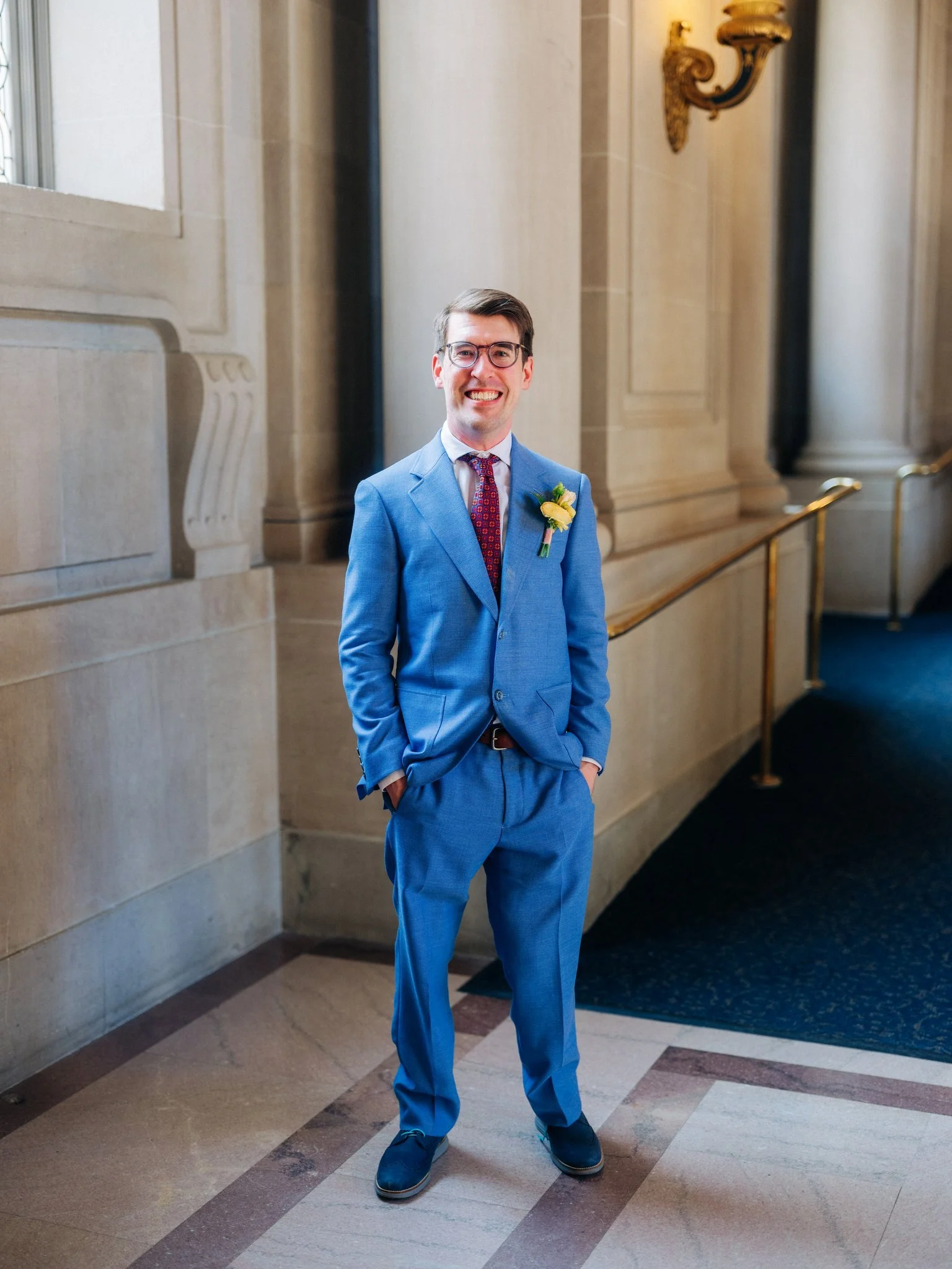 Groom smiling at camera in City Hall hallway during San Francisco City Hall wedding