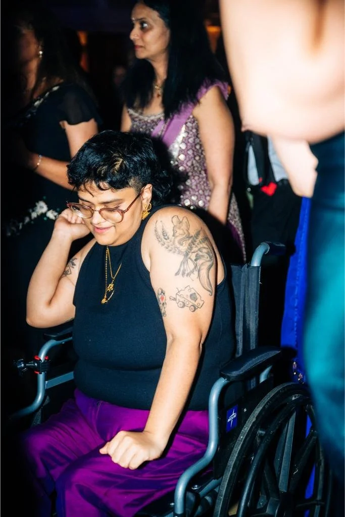 Wedding guest using a wheelchair dancing on the reception dance floor
