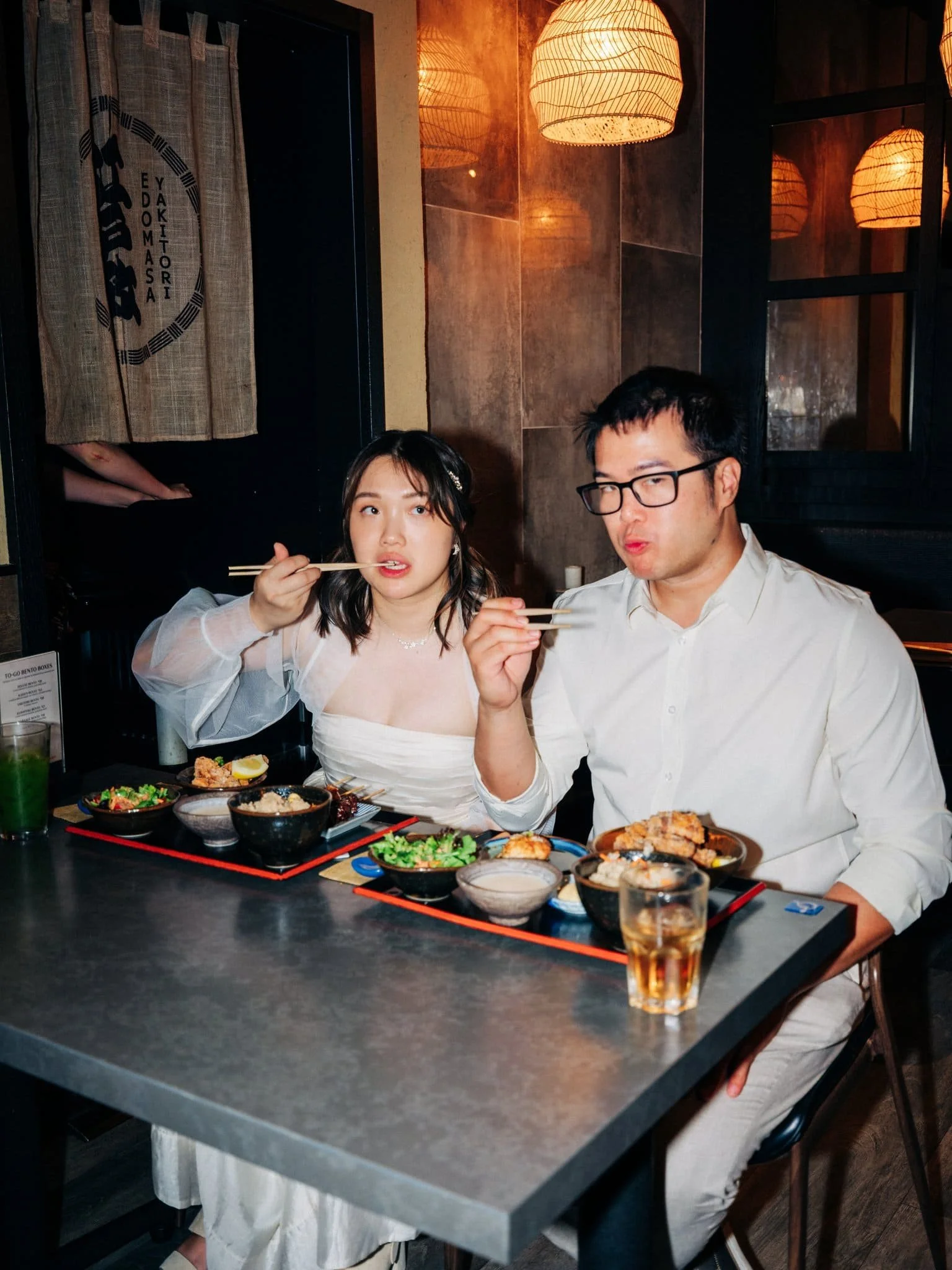 Bride and groom eating together at Yakitori Edomasa during their San Francisco Japantown elopement celebration.