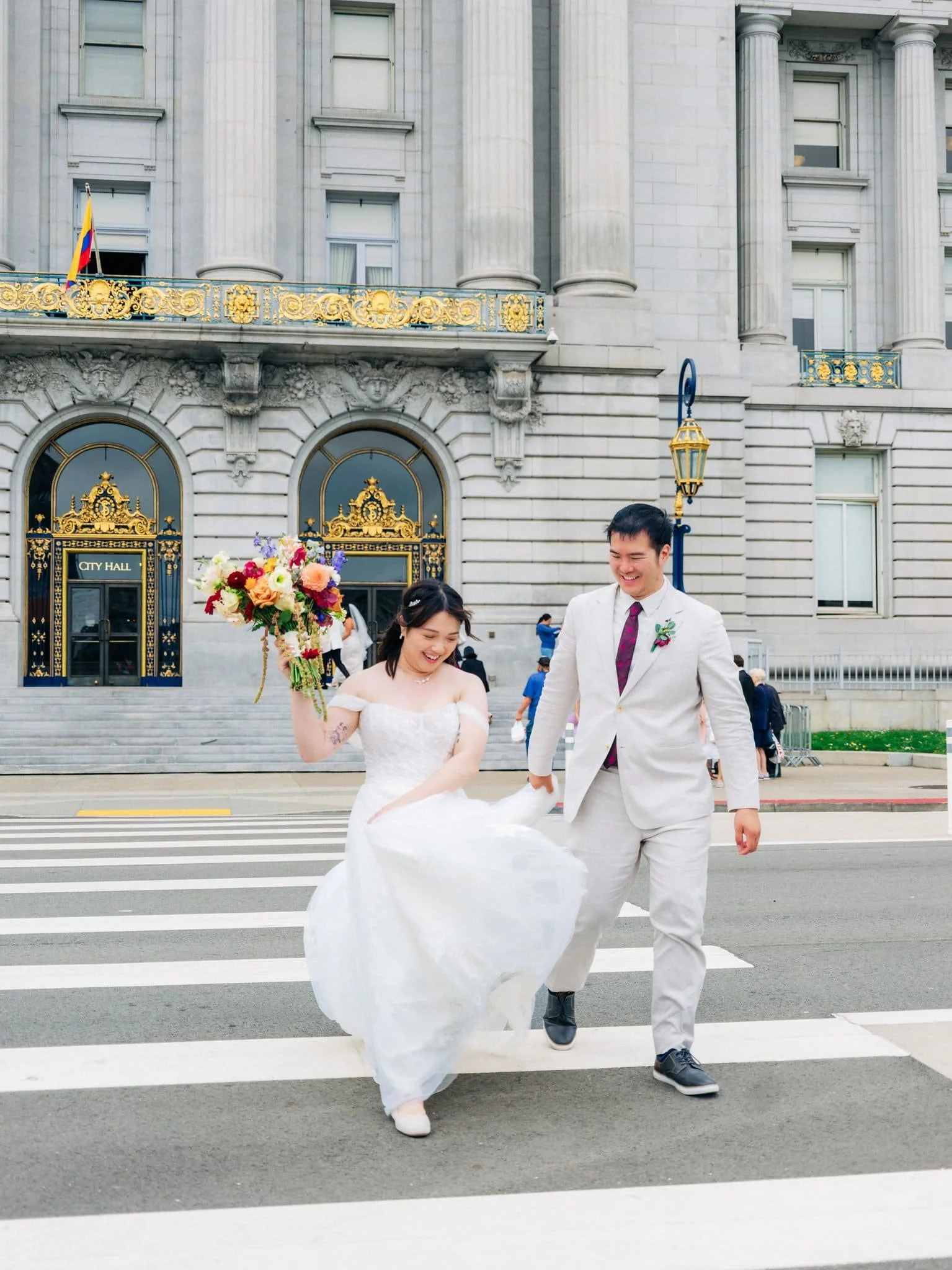 Bride and groom crossing the street after leaving San Francisco City Hall following their elopement.