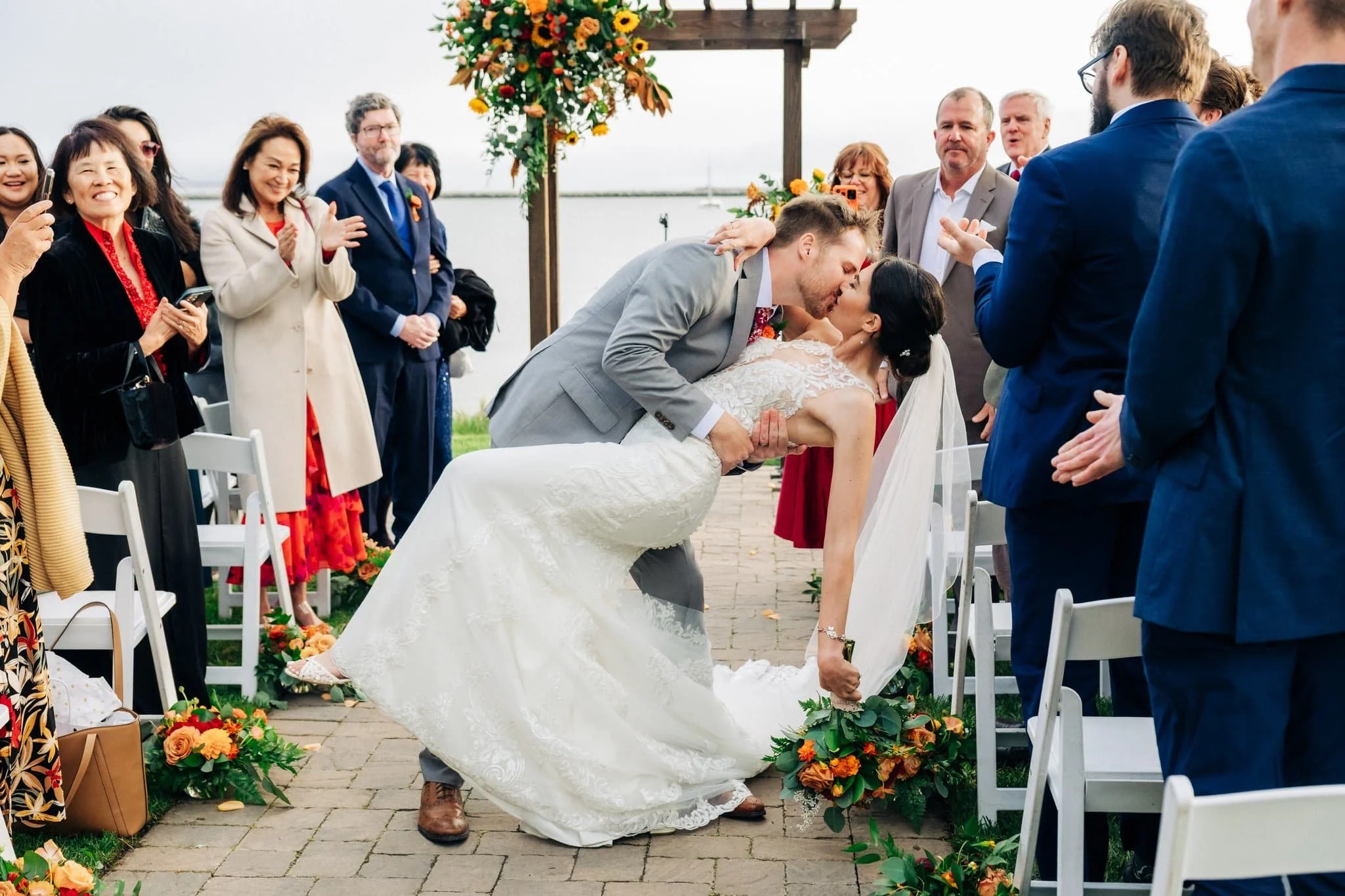 Bride and groom sharing first kiss during ceremony at Maverick’s Beach House wedding in Half Moon Bay