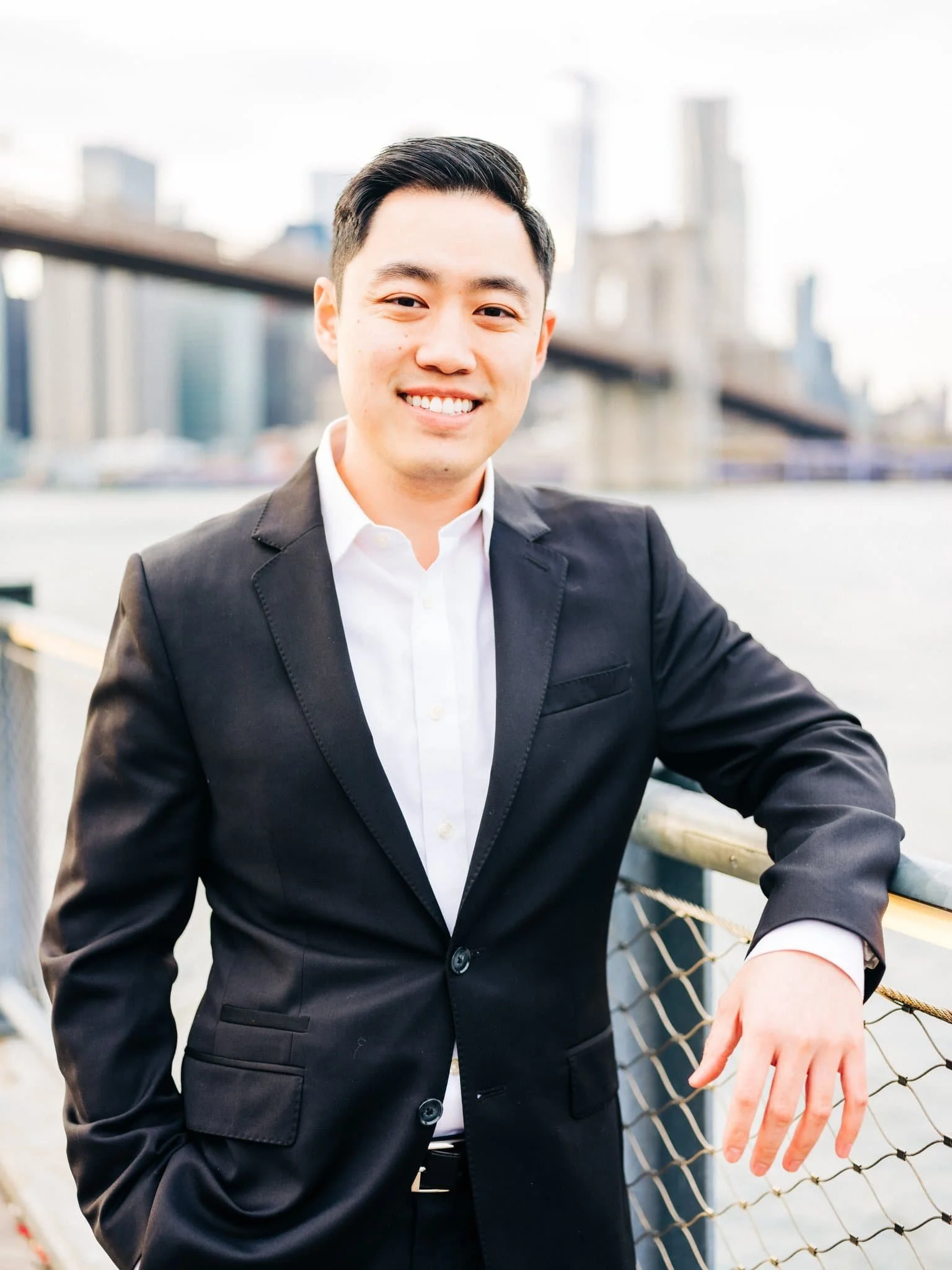 Portrait of the groom-to-be with the Brooklyn Bridge behind him during their New York engagement session.