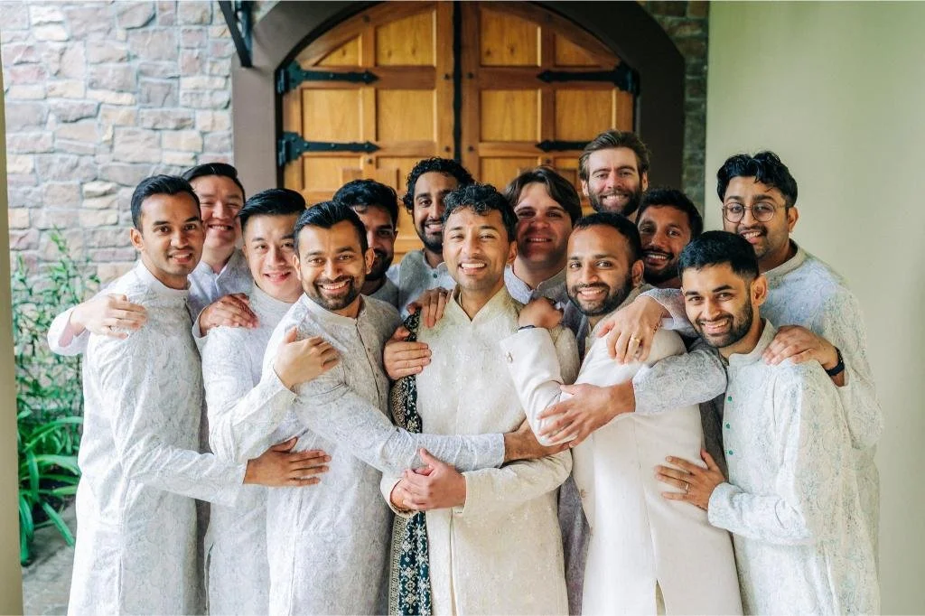 Groom and groomsmen sharing a hug before the wedding