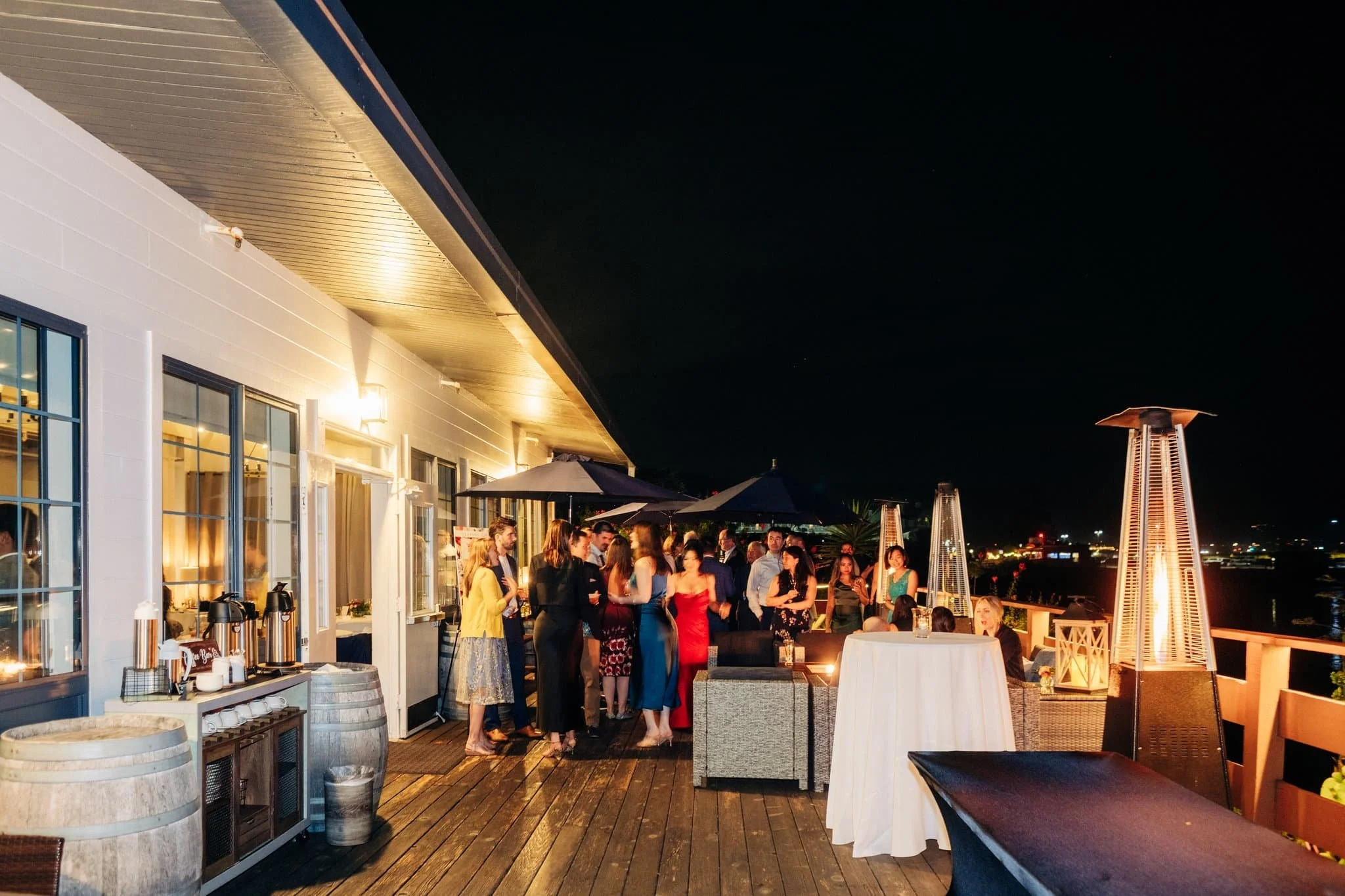 Wedding guests mingling on the deck overlooking the ocean during the reception at Maverick's Beach House in Half Moon Bay