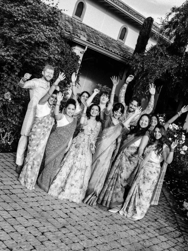 Bride and bridal party celebrating together with their hands in the air