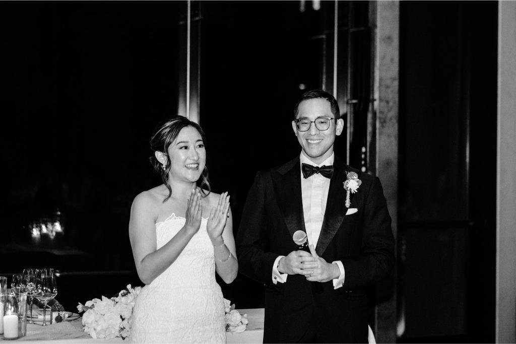 Bride and groom speaking to their guests during the wedding reception