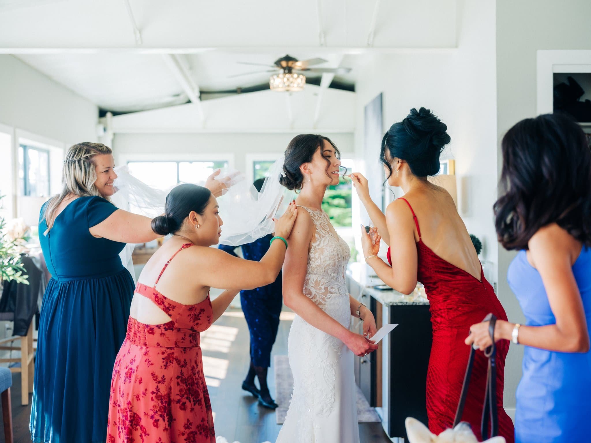 Bridesmaids helping bride with makeup while getting ready for Maverick’s Beach House wedding in Half Moon Bay