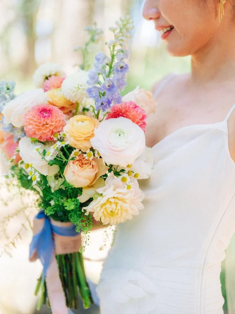 Bride looking down and smiling at her bouquet during portraits at Lover's Lane.