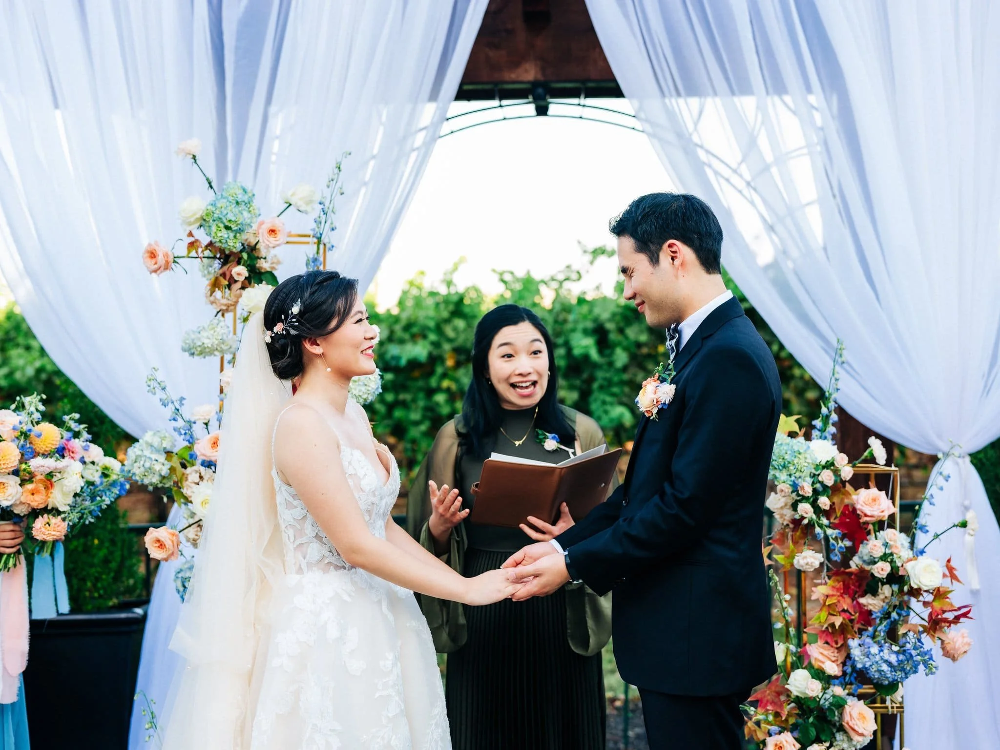 bride and groom holding hands during ceremony with officiant palm event center pleasanton wedding