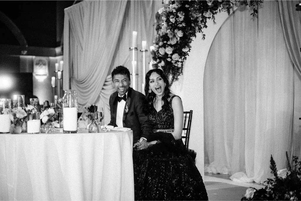 Bride and groom laughing together during a wedding reception speech