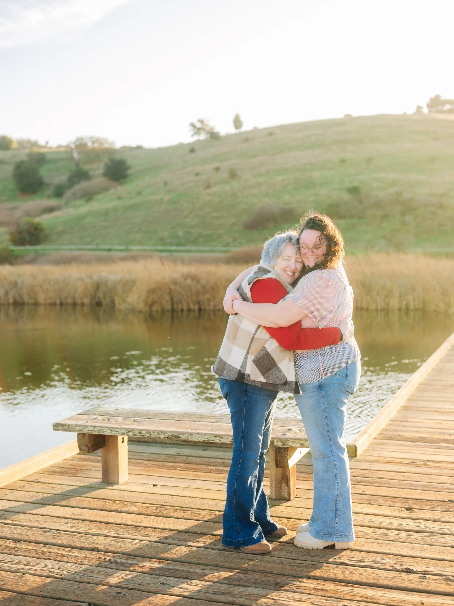 Mother and daughter embracing on a dock during a family photo session at Coyote Hills Regional Park in Fremont CA