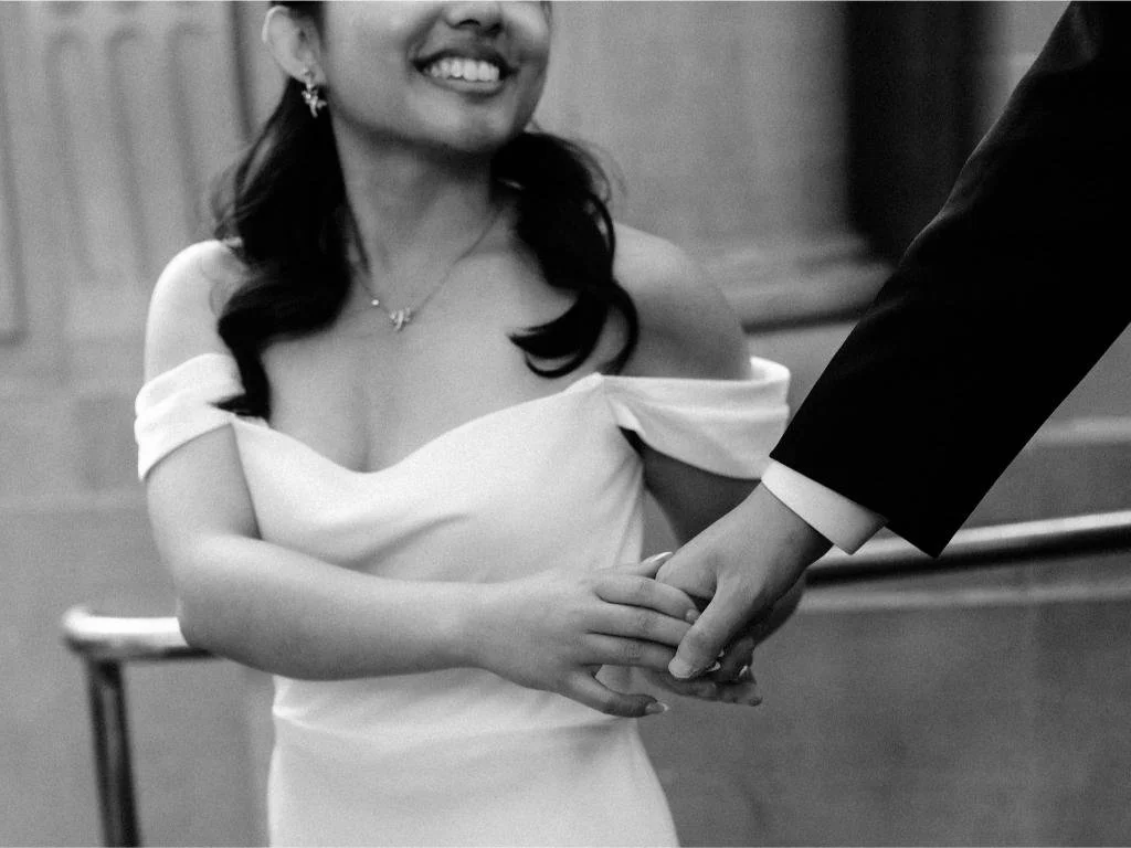 Close-up of the bride holding the groom's hand inside San Francisco City Hall