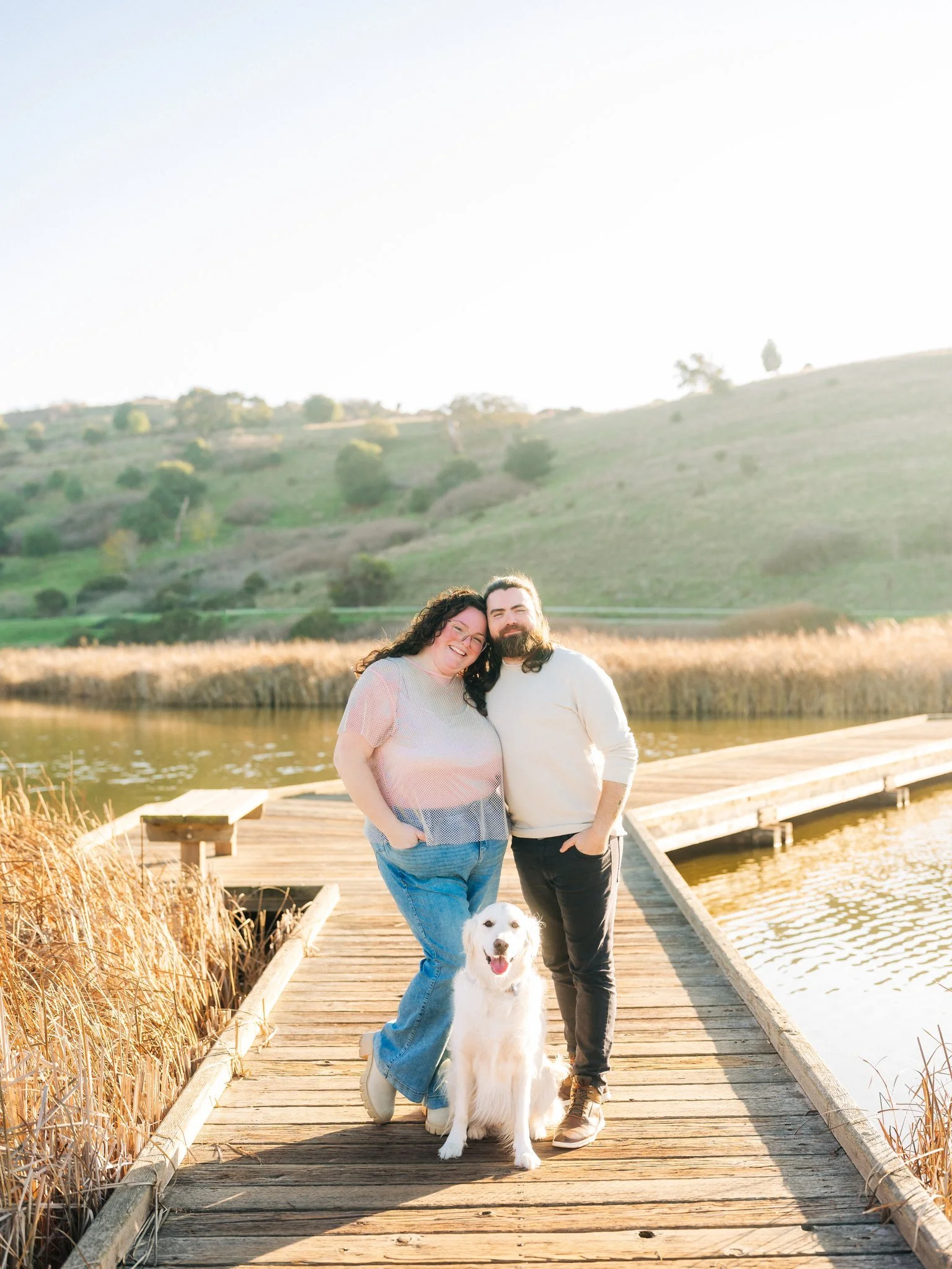 Couple posing with their dog on a dock at Coyote Hills Regional Park in Fremont CA during a couples photo session