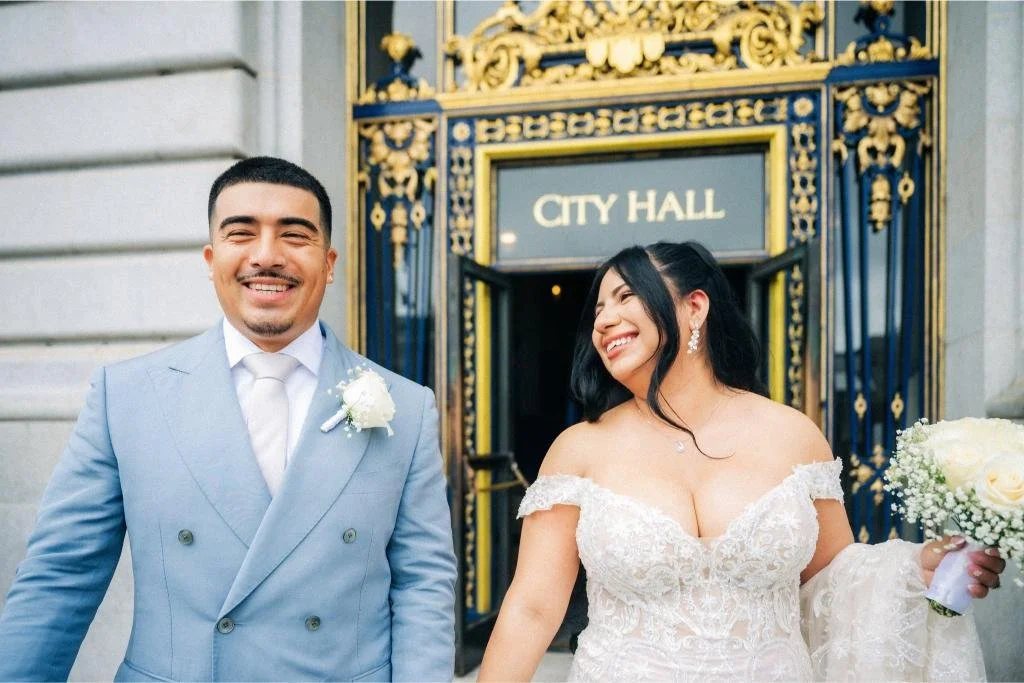 Bride and groom standing outside the City Hall entrance.