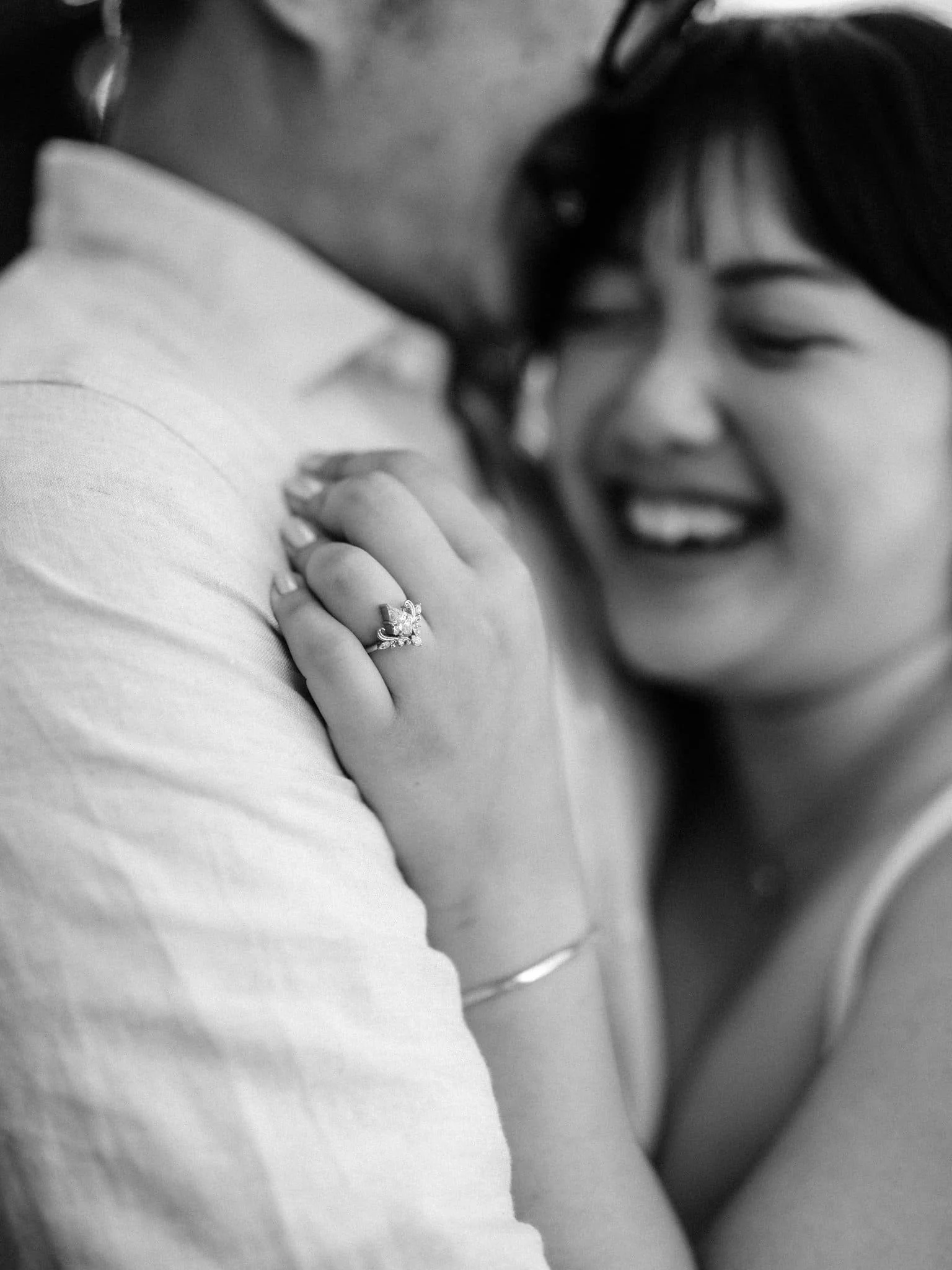 Close-up of her engagement ring as she embraces him during their Montalvo Arts Center engagement photos in Saratoga.