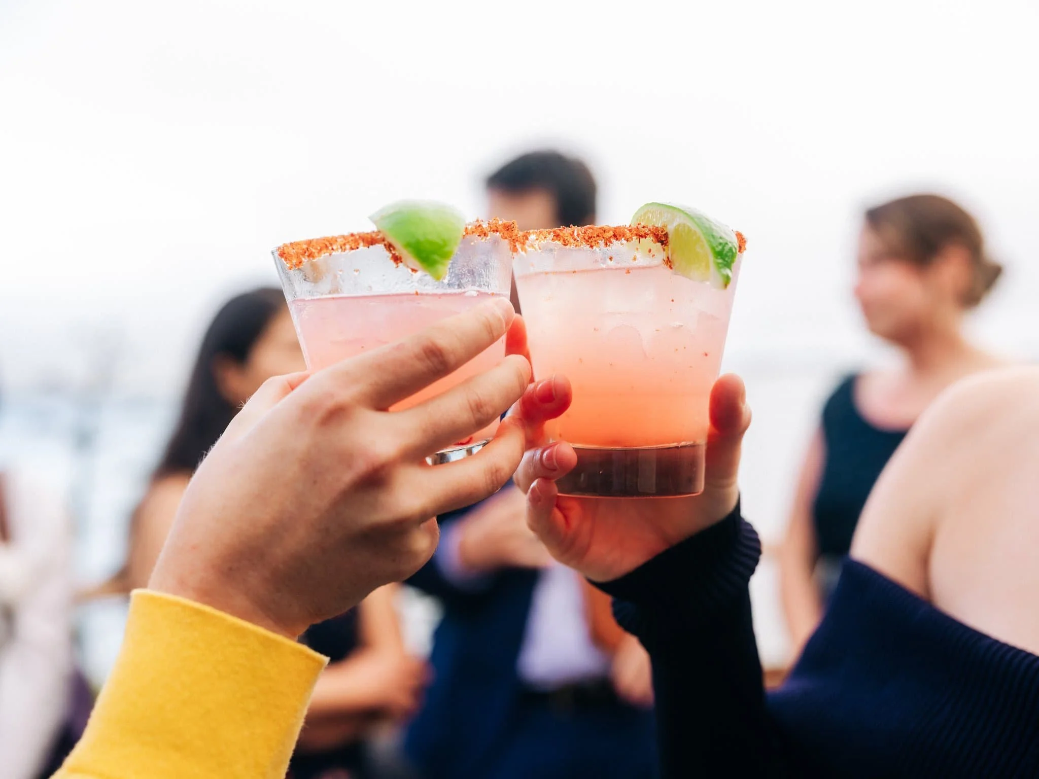 Guests raising cocktails in a celebratory toast during cocktail hour at Maverick's Beach House in Half Moon Bay