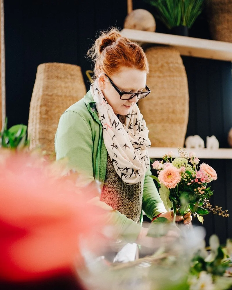 Floristin Jessi konzentriert beim Binden eines frischen Blumenstraußes in der Gärtnerei Dumbsky Hechenwang