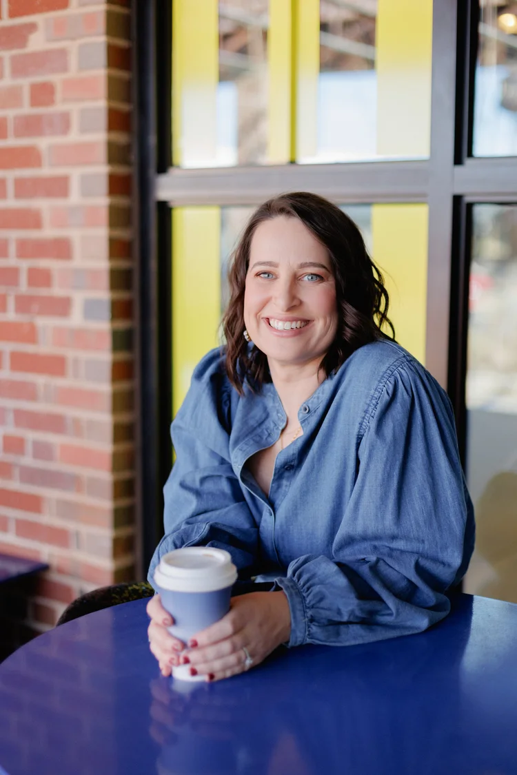 Suzanne Patel smiling while seated with a cup of coffee
