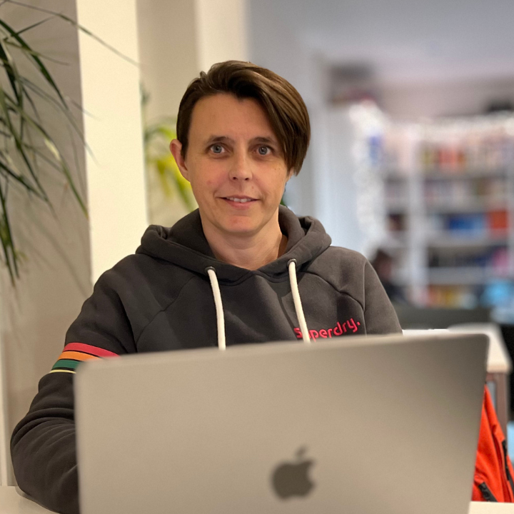 Karen Cooke sat at her laptop with short dark hair and a grey hoodie