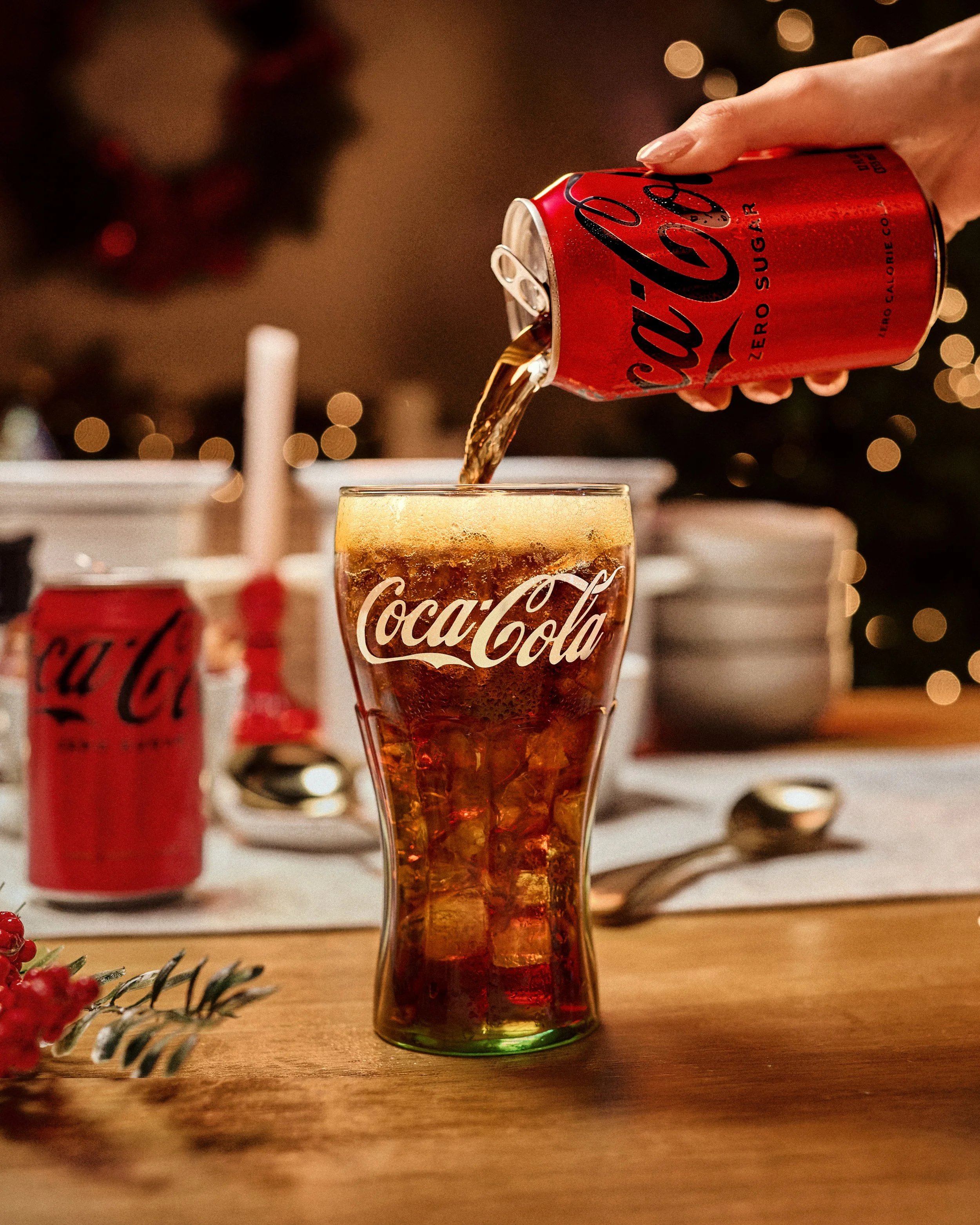 Coca-Cola being poured into a branded Coca-Cola glass at a holiday-styled table for the Walmart retail campaign