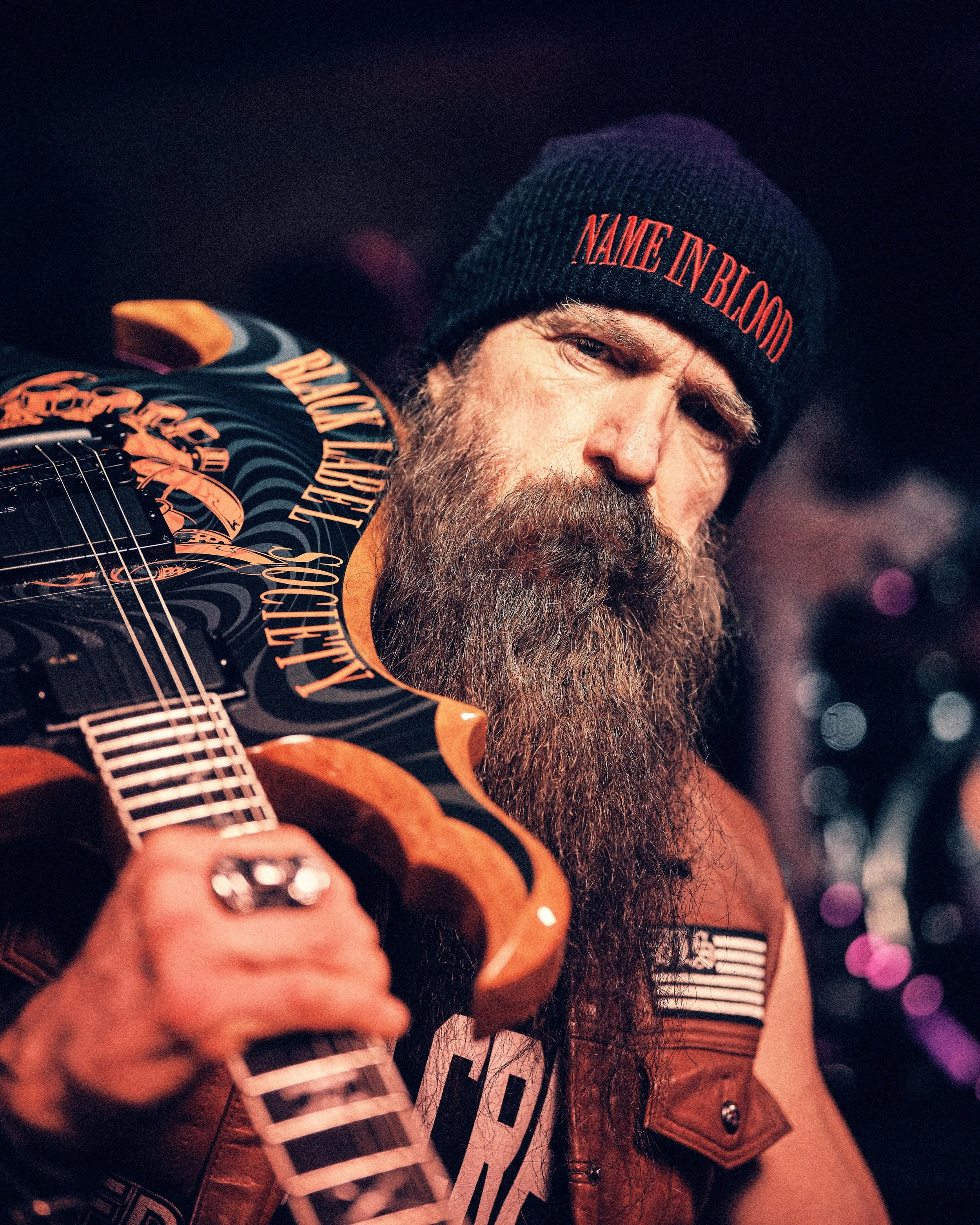 Close-up portrait of Zakk Wylde holding his Black Label Society signature Wylde Audio guitar.
